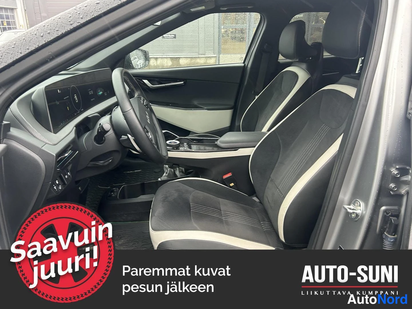 Muu: Kia EV6 -auton matkustamo: ohjauspyörä, kaareva infotainment-näyttö ja kaksiväriset verhoillut etuistuimet.