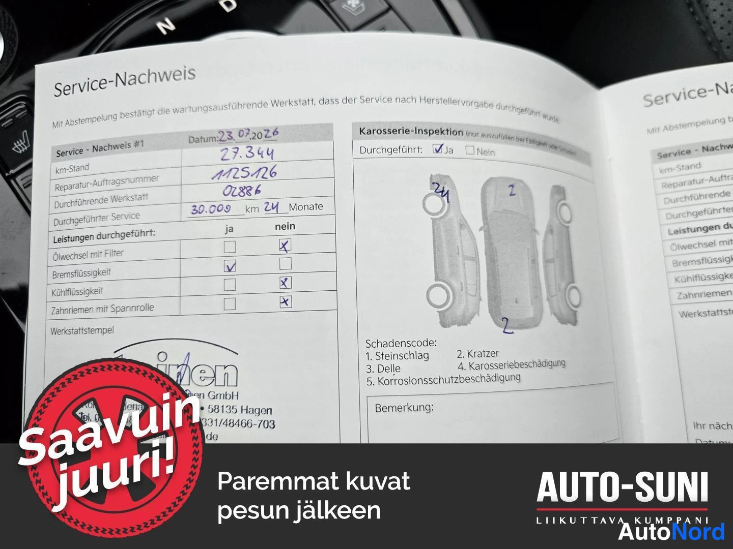 Asiakirja: Kojelaudalla avoinna oleva saksankielinen huoltokirja (Service-Nachweis), jossa käsinkirjoitettuja huoltotietoja, valintaruutuja ja työhuoneen leima; kuvan alar