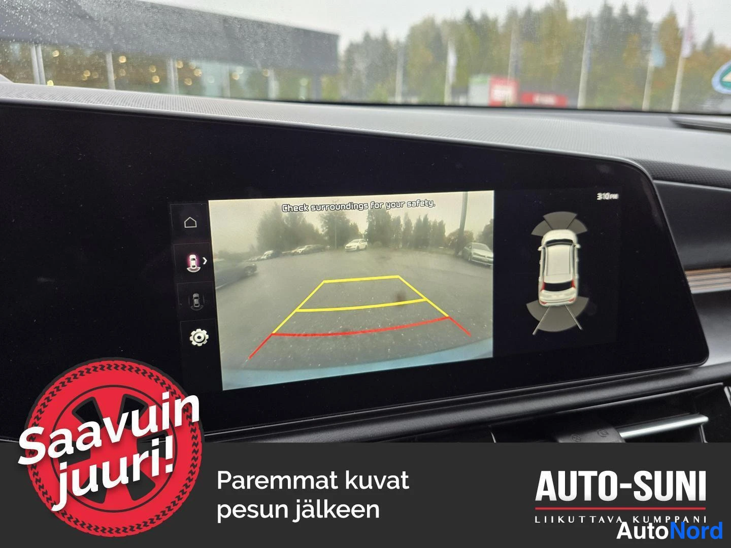 Yksityiskohta: Taakseajoa auttava kamerakuva auton kosketusnäytöllä ohjaustekstillä ja etäisyysviivoilla.