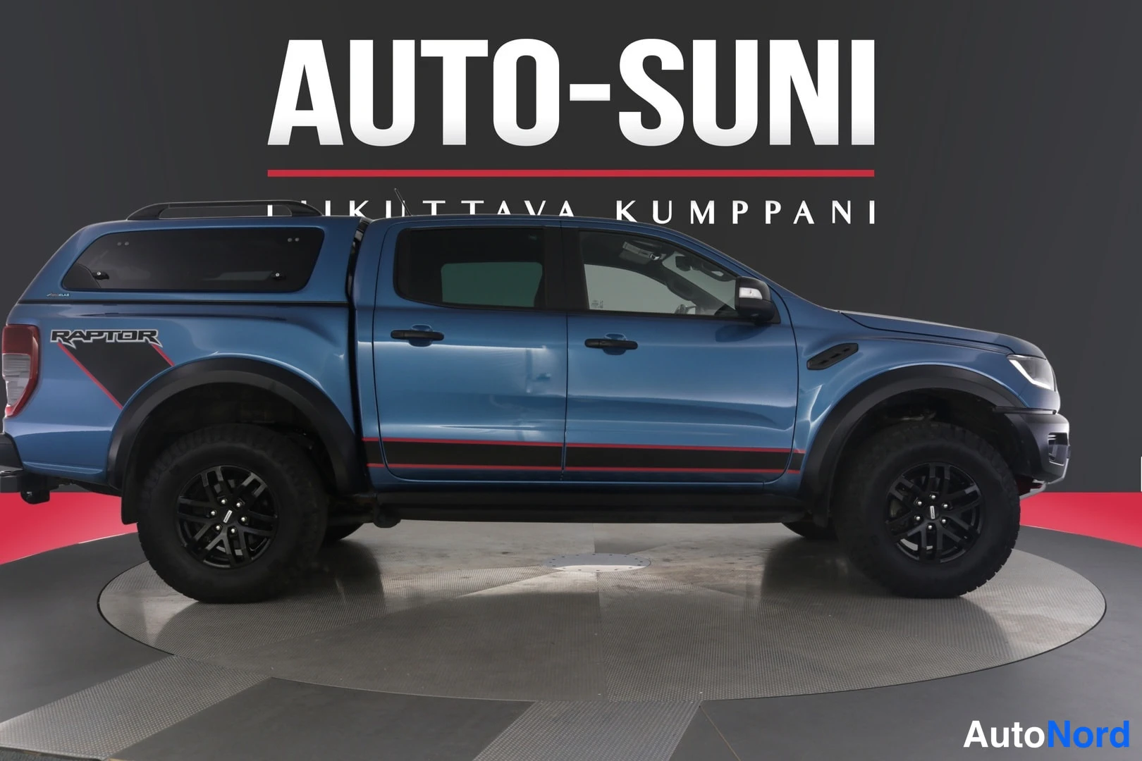 Etuviisto, nokka oikealle: Sininen Ford Ranger -lava-auto sivulta nähtynä, Mustien kevytmetallivanteiden alla, näkyy takaholkkien yllä oleva kulmikas valot.