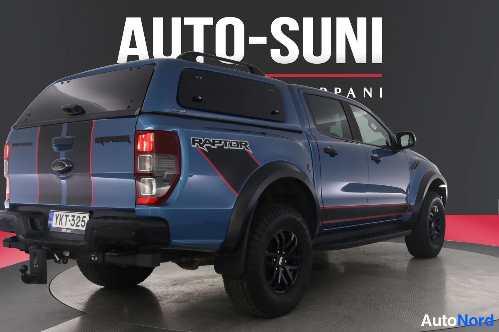Takaviisto: Sininen Ford Ranger -lava-auto takaviistosta, RAPTOR-teksti lavan sivussa ja rekisterikilpi.