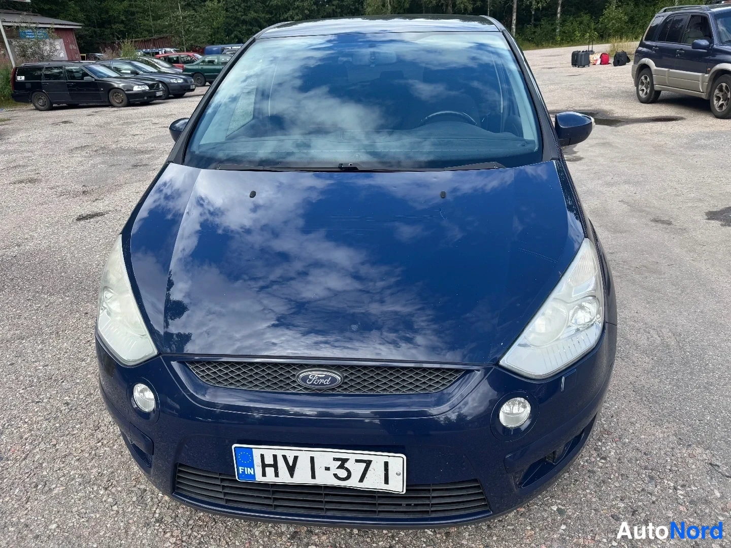 Edestä: Auton keula suoraan edestä kuvattuna: tummansininen konepelti ja puskuri, Ford-merkki etusäleikössä, sumuvalot puskurin kulmissa ja rekisterikilpi.