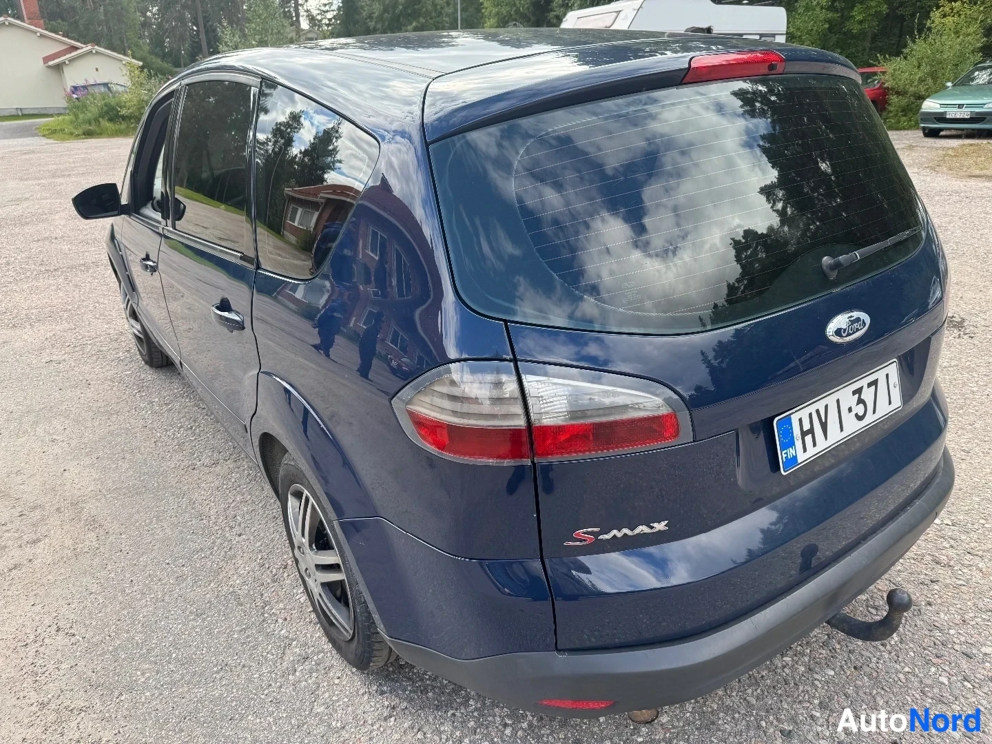 Takaviisto: Sinisen tila-auton takakulmanäkymä; rekisterikilpi HV I-371, S-MAX-merkintä ja nokka-aihe…