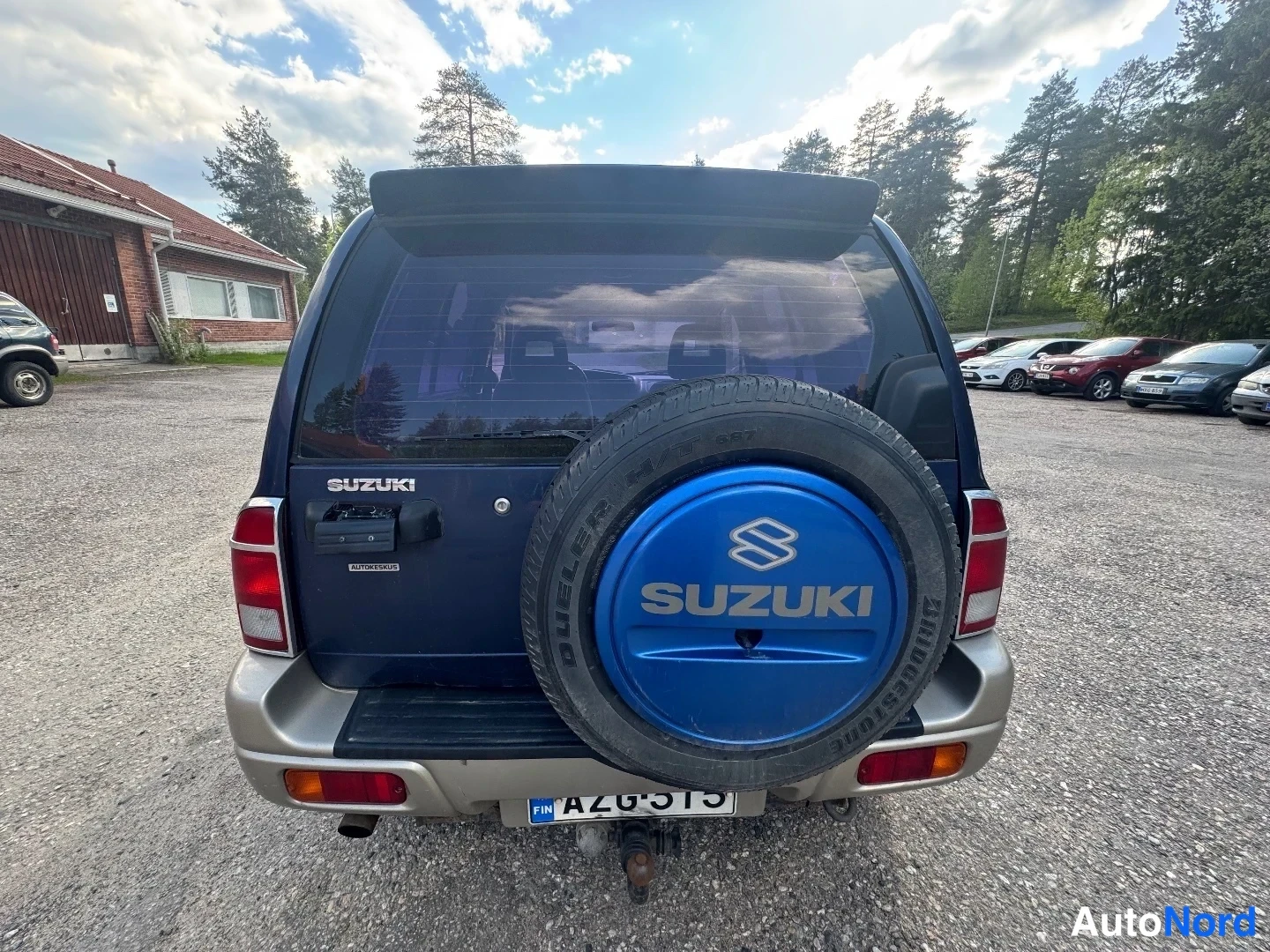 Takaa: Sinisen Suzuki Grand Vitaran takaosa, varapyörä kannella ja rekisterikilpi FIN.