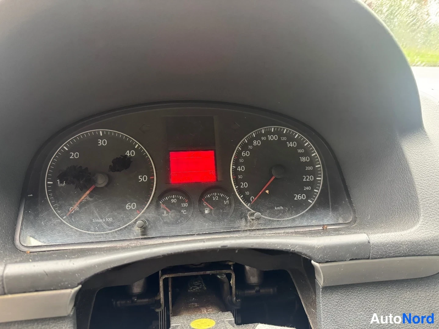 Muu: Henkilöauton kojelauta lähikuvassa: vasemmalla kierroslukumittari (asteikko 1/min x 100), oikealla nopeusmittari asteikolla 10–260 km/h, keskellä punainen nlein