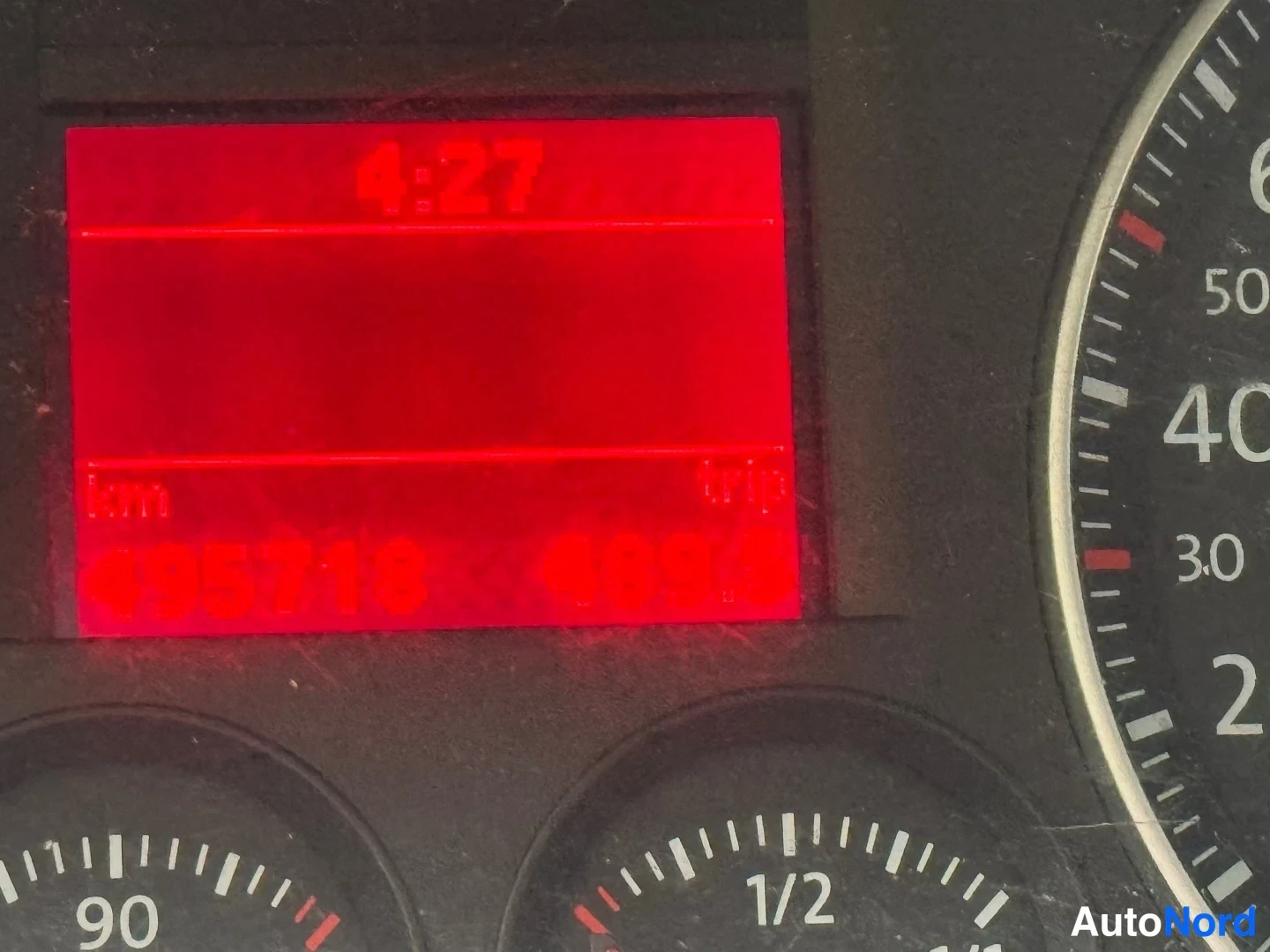 Muu: Kojetaulun punainen nestekidenäyttö näyttää kilometrilukeman 495718 km, triplaskurin ja kellonajan 4:27.