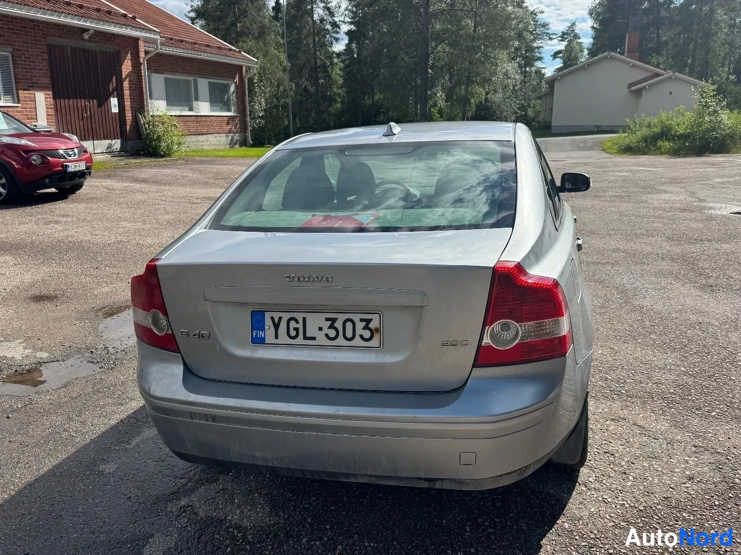 Takaviisto: Auton takaosa suoraan takaa: hopeanvärinen sedan, rekisterikilpi, VOLVO-teksti ja S40-merkintä konepellin takapuolella.