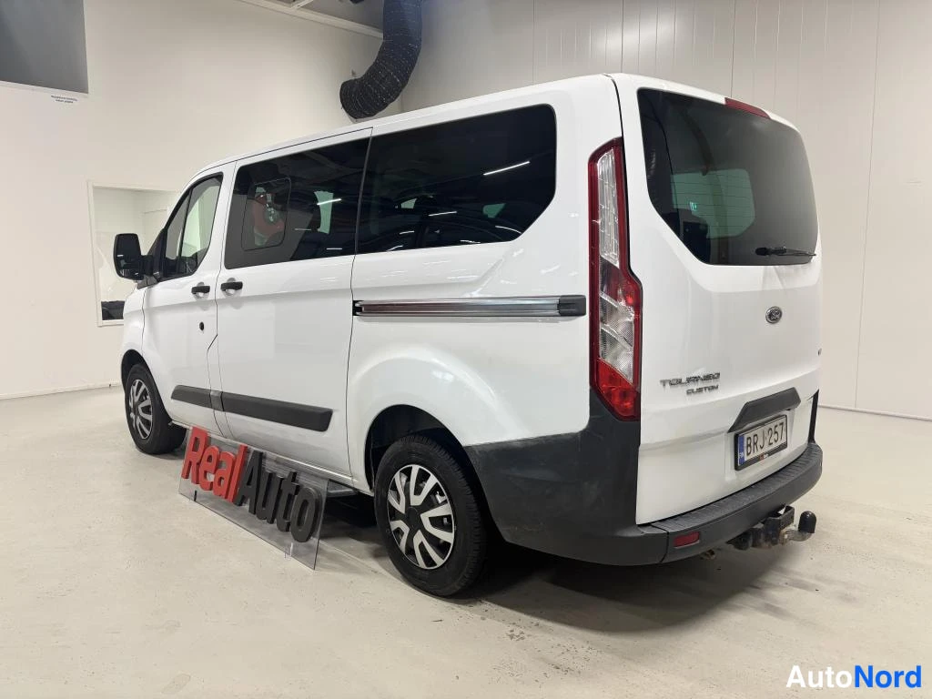 Takaviisto: Valkoinen Ford Tourneo Custom taka-kulmakuvassa, rekisteritunnus.