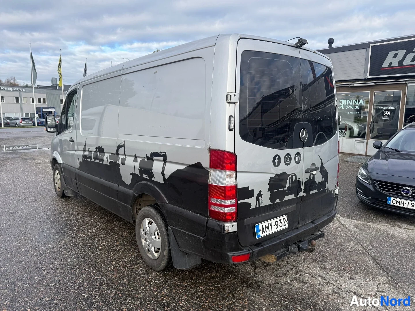 Takaviisto: Hopeanharmaa pakettiauto taka­kolmannes­kulmassa oikealta, takapöttelö ja oikea sivu näkyvissä.