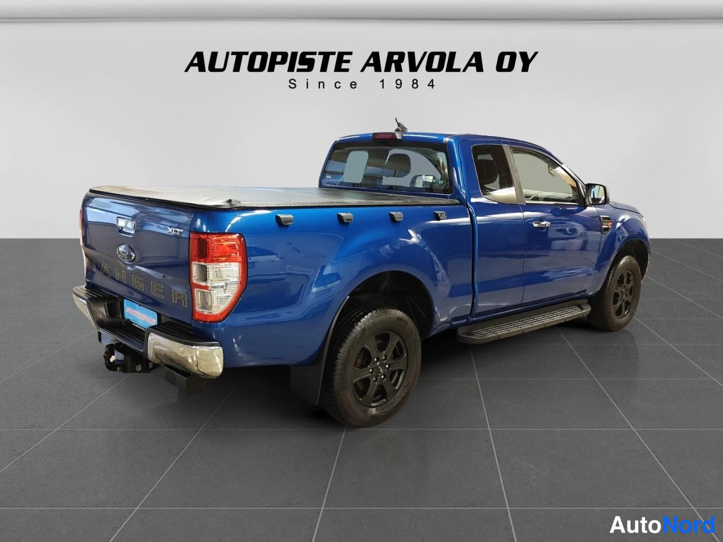 Takaviisto: Sininen Ford Ranger -navetta takaviistosta kuvattuna, tavaratila peitolla.