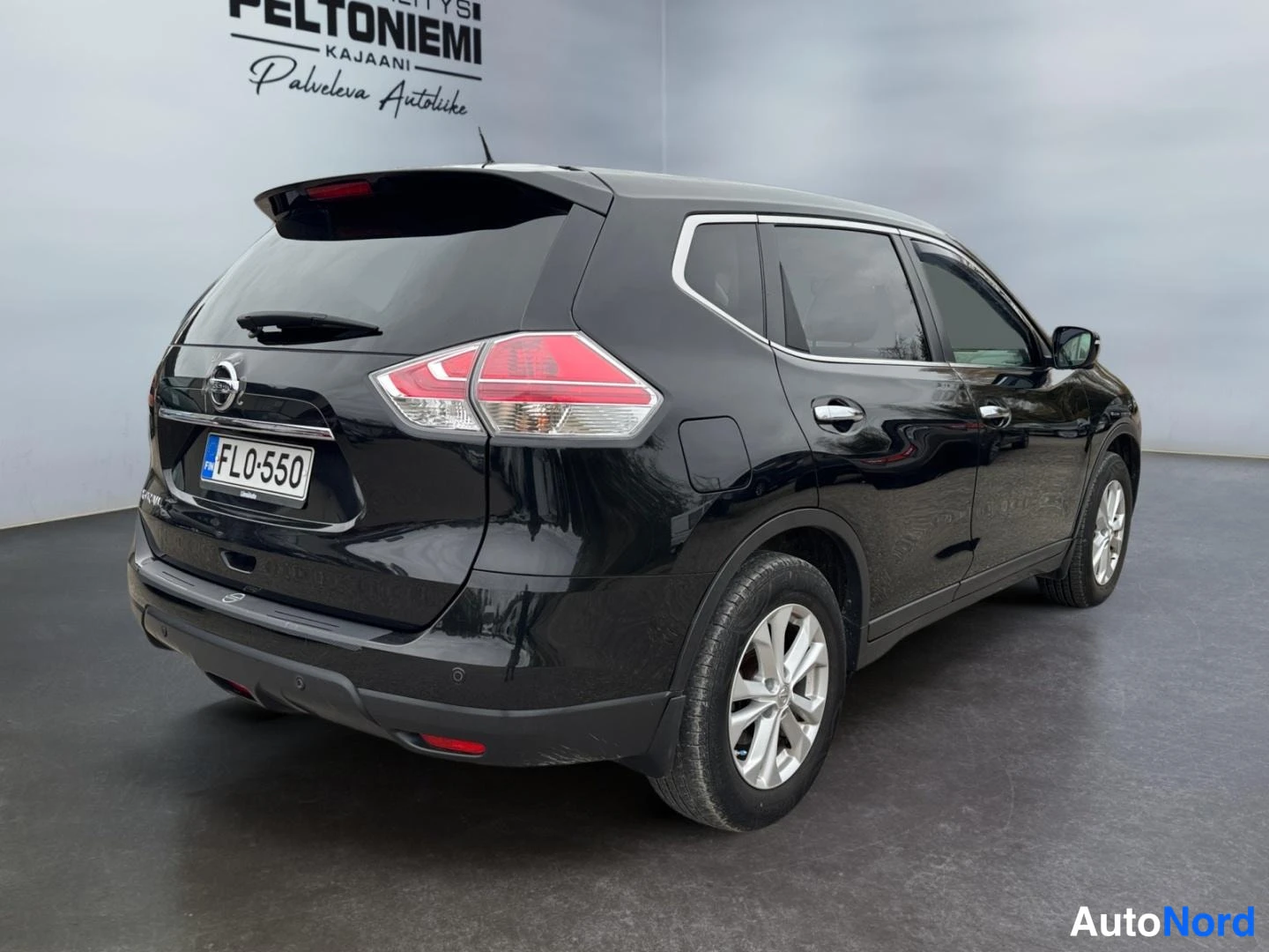 Takaviisto: Musta tila-auto takakulmasta, rekisterikilpi FL0-550.