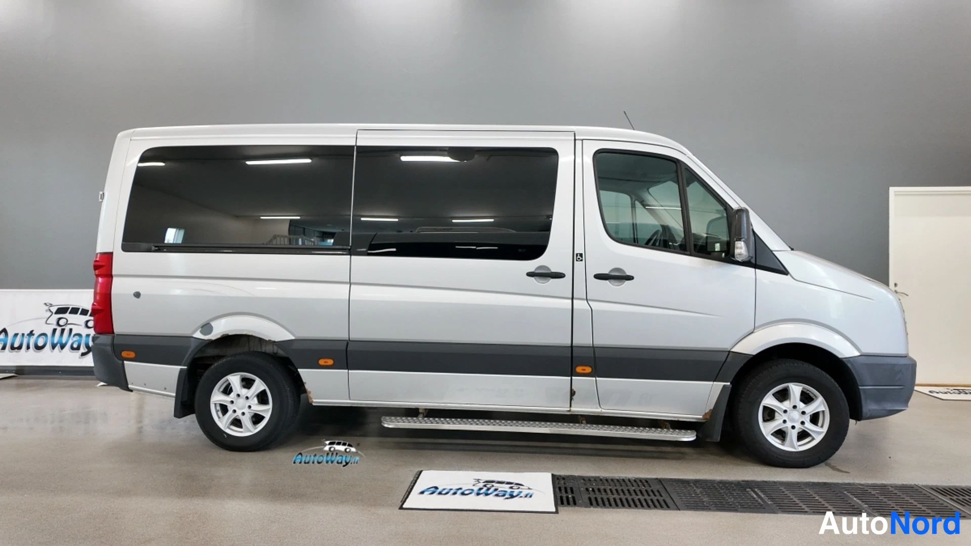 Takaviisto: Hopeanvärinen Volkswagen Crafter -pakettiauto sivulta vasemmasta suunnasta sisätiloissa.