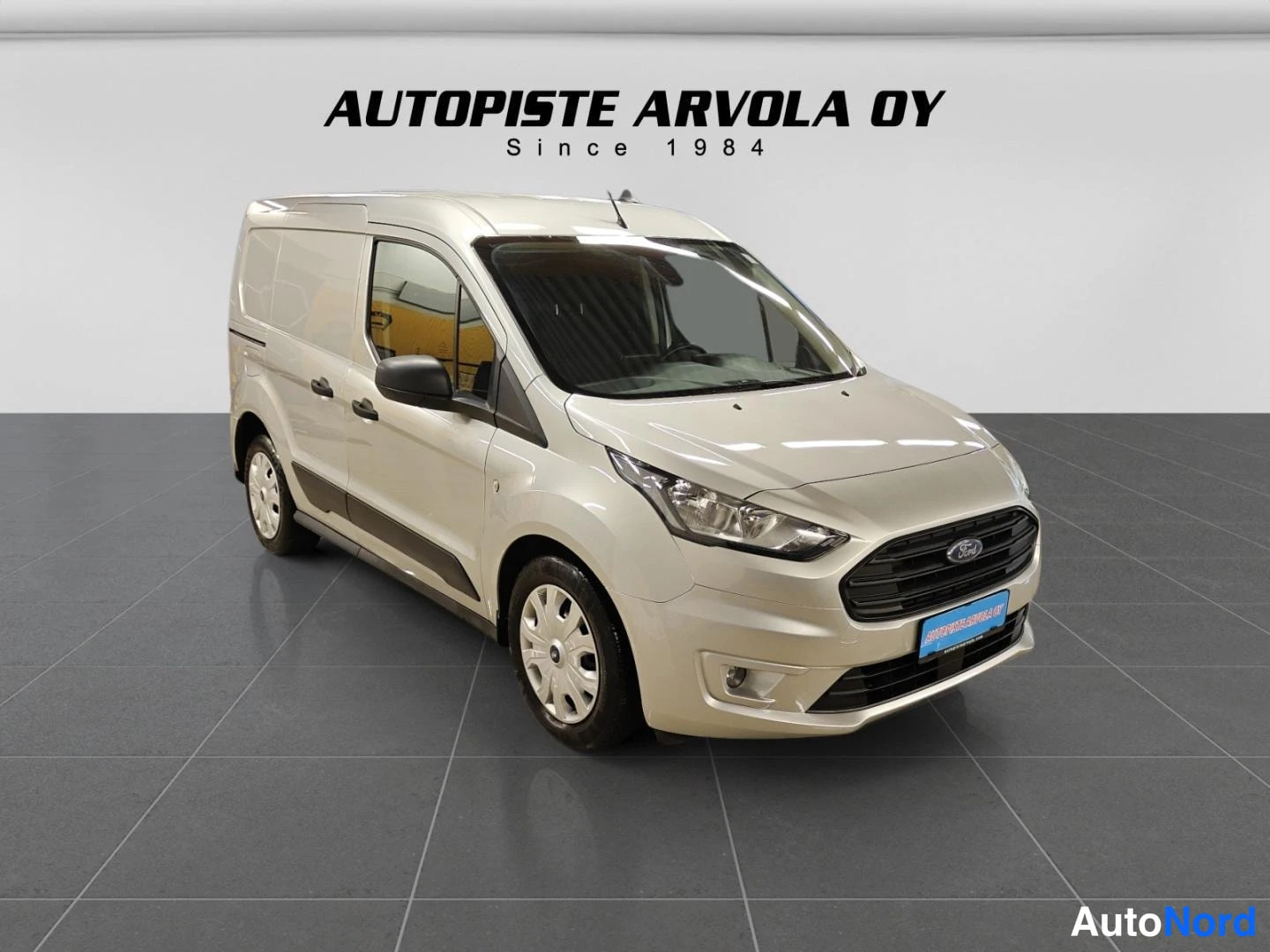 Etuviisto, nokka oikealle: Ford Transit Connect -pakettiauto edestä vasemmalta kuvattuna, vaalean beigeäsävyinen korimuotoilu näkyy myös kyljessä.