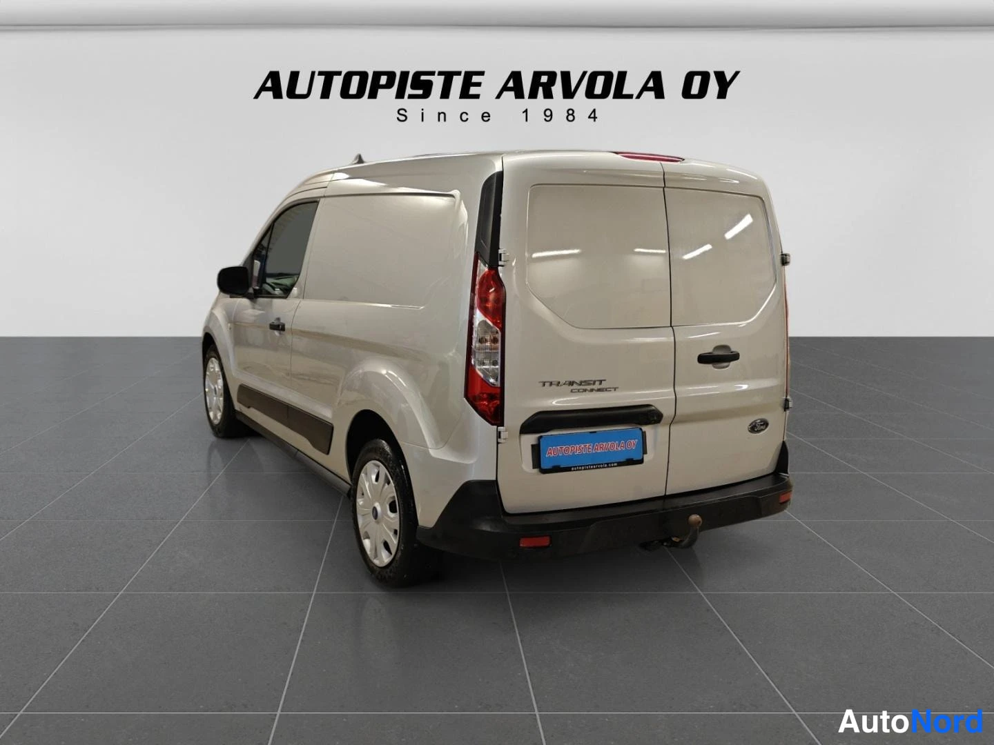 Takaviisto: Ford Transit Connect -pakettiauto takaa vasemmalta kuvattuna, takaportit ja vasen kylki näkyvät.