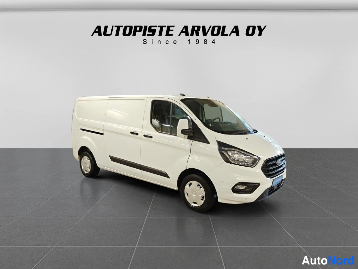 Etuviisto, nokka oikealle: Ford Transit Custom -pakettiauto etu kolmasosa vasemmalta, valkoinen koripaneelit