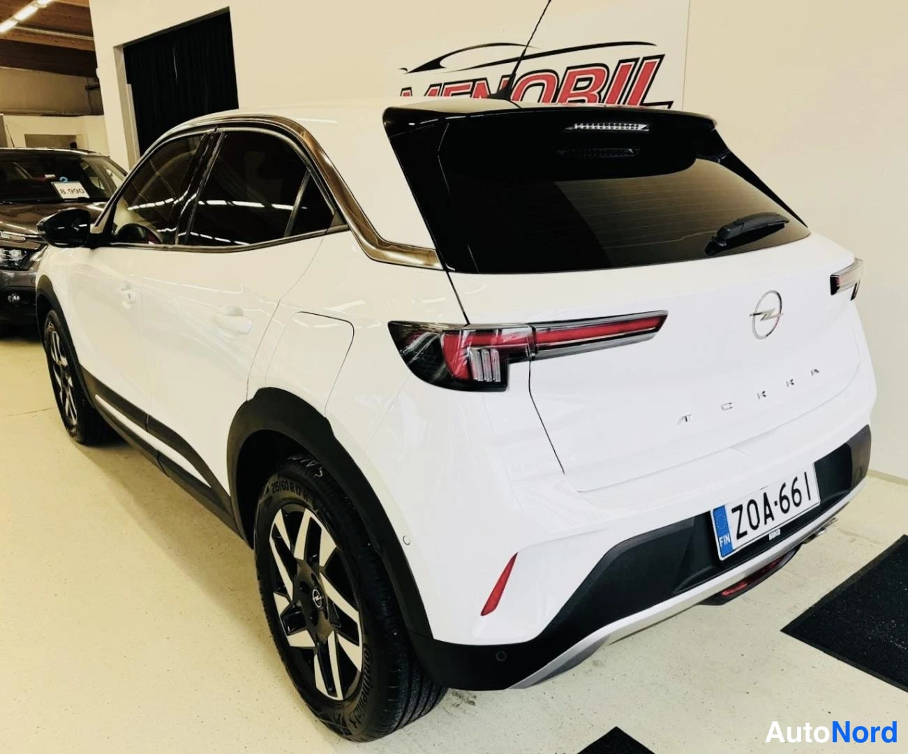 Takaviisto: Valkoinen Opel Mokka takaviistosta vasemmalta, rekisteritunnus.