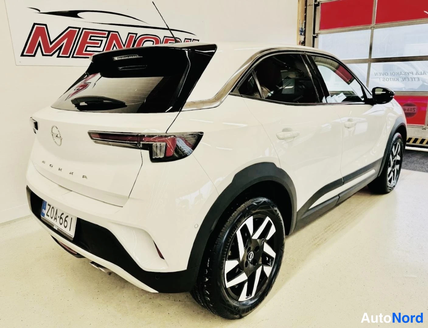 Takaviisto: Valkoinen Opel Mokka takaviisto sisätiloissa, rekisterikilpi.