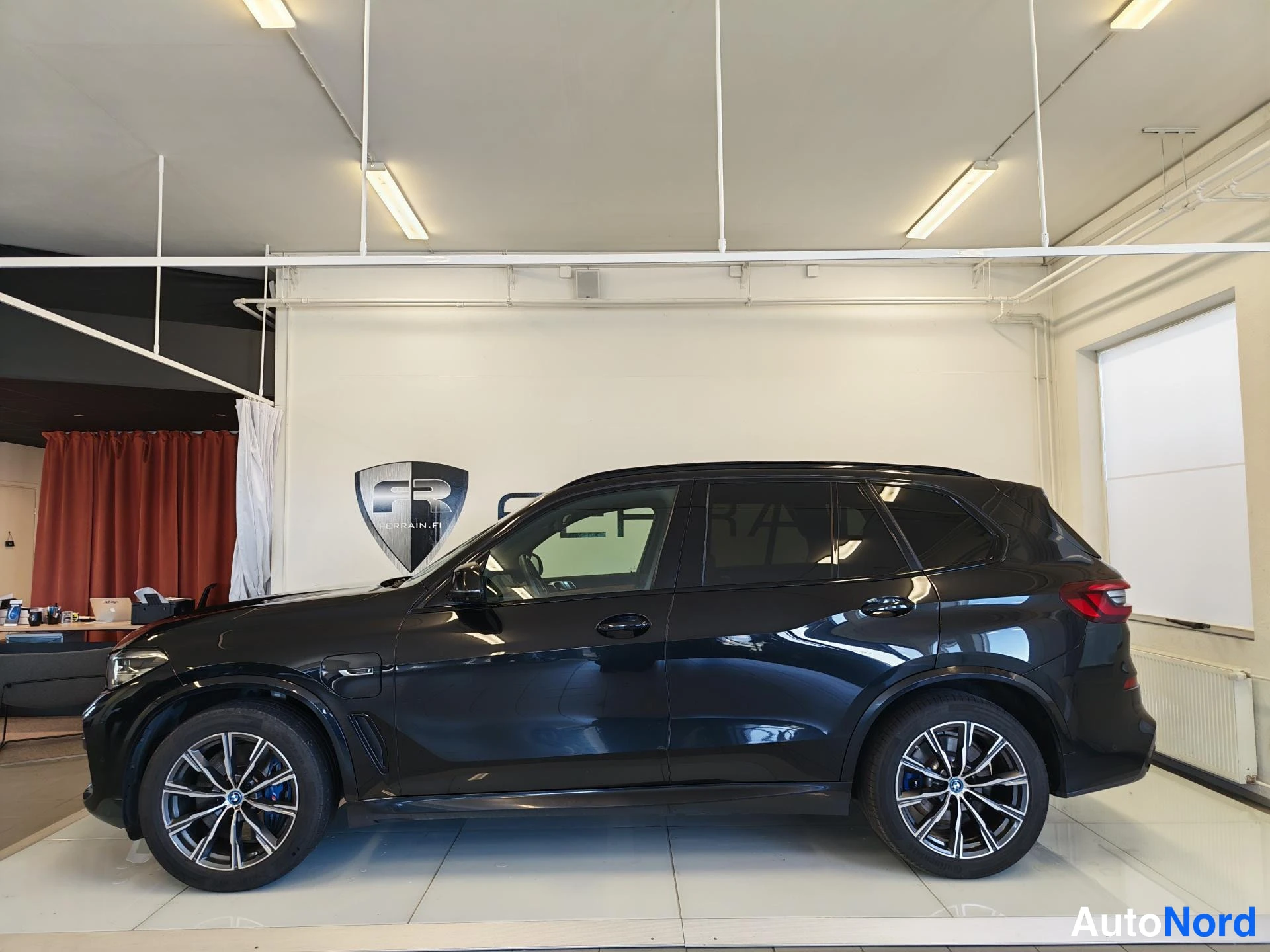 Sivulta: BMW X5 musta sivuprofiili ajoneuvosalissa