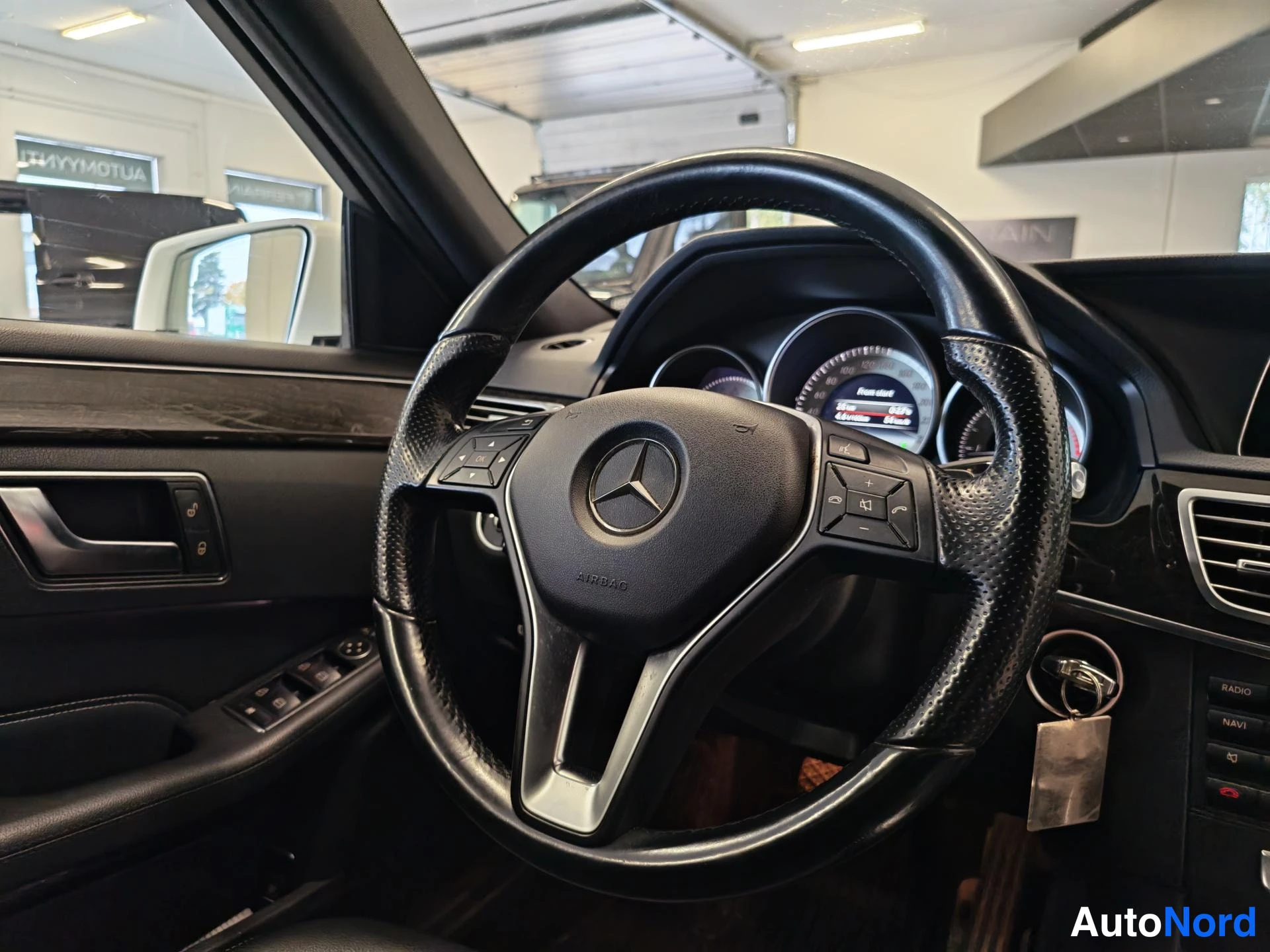 Muu: Mercedes-Benz-ohjaamon ohjauspyörä lähikuvassa, mittaristo taustalla.