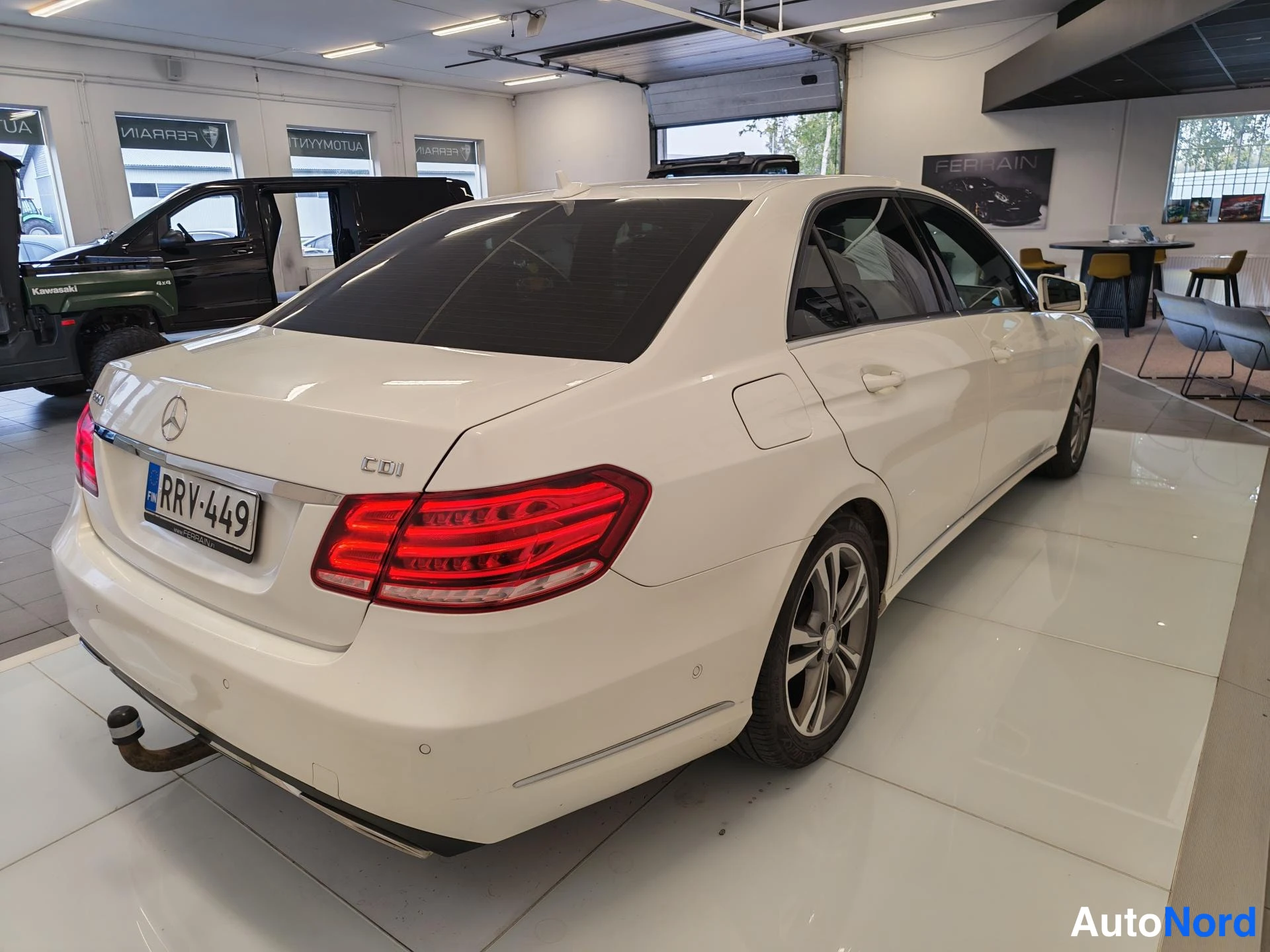 Takaviisto: Auton takakulma sivulta: valkoinen Mercedes-Benz -sedan, takavalo punainen, rekisterikilpi, takapuskurissa vetokoukun kaula ja merkintä CDI.