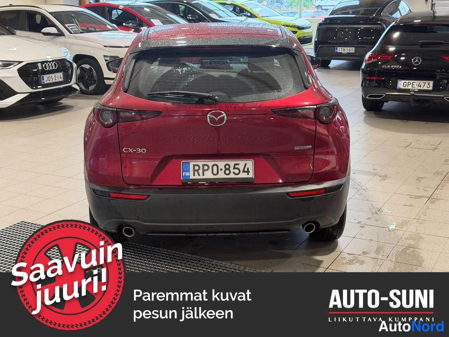 Takaa: Punaisen Mazda CX-30:n takaosa suoraan takaa, CX-30-teksti ja rekisterikilpi.