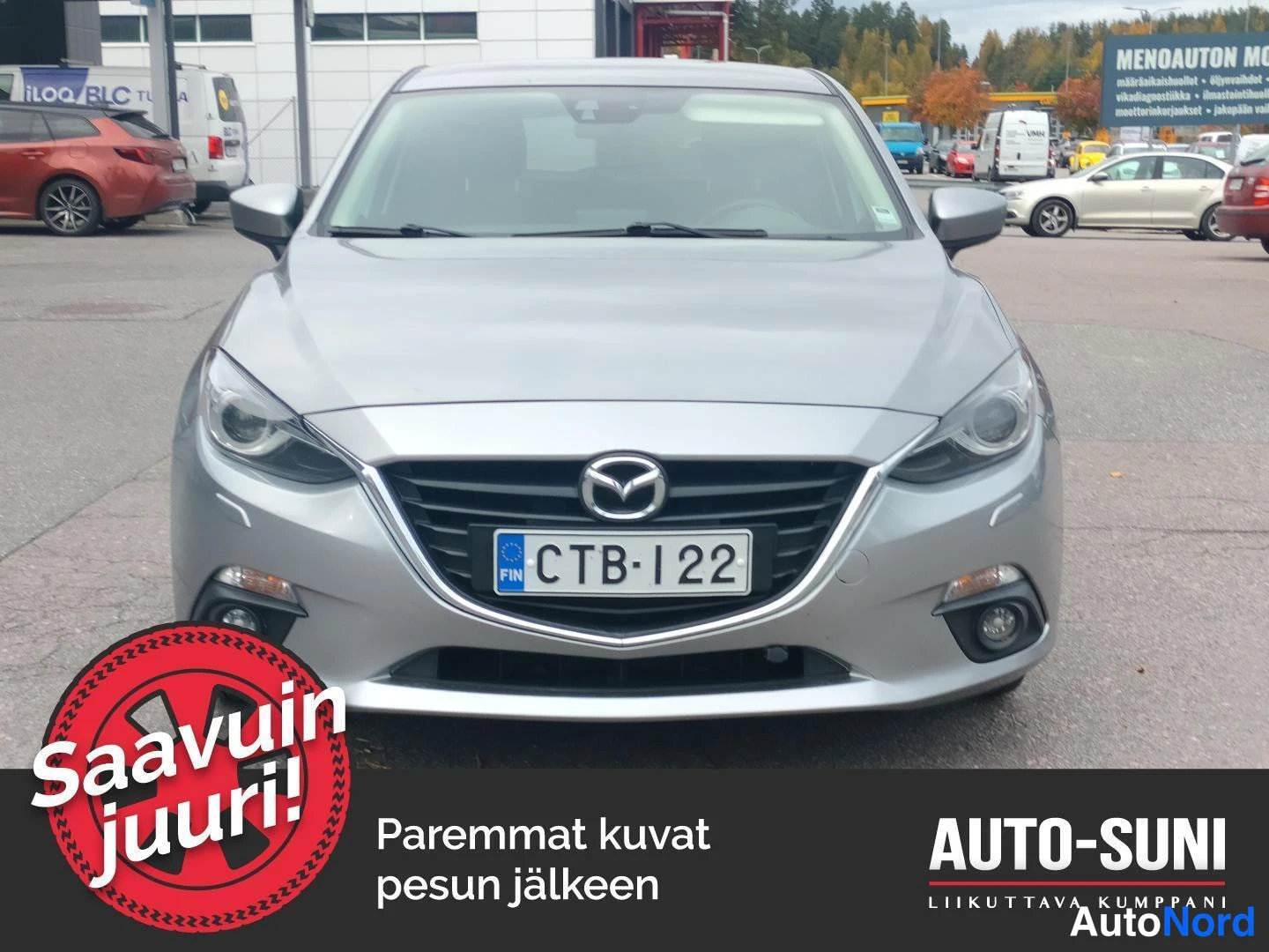Edestä: Hopeanvärinen Mazda3 edestäpäin, etusäleikkö ja Mazda-merkki näkyvissä, rekisterikilpi.