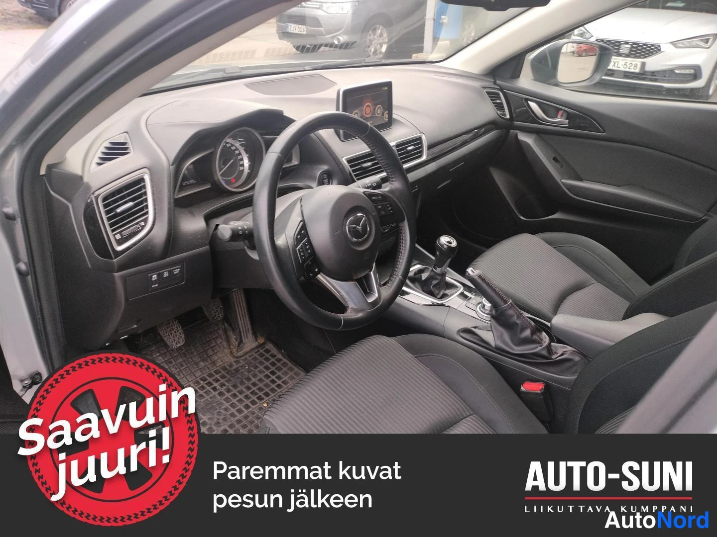 Muu: Mazda3:n ohjaamo vasemmalta: rattipyörä, manuaalivaihteiston vaihdekeppi ja tummat kangasistuimet.
