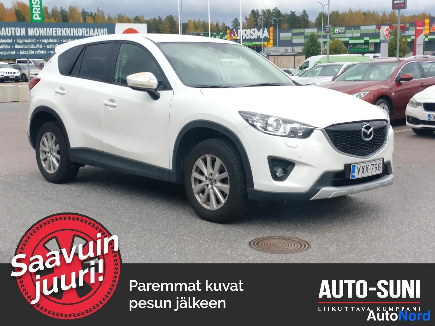 Etuviisto, nokka oikealle: Valkoinen Mazda CX-5 -henkilöauto kuvattu kolmannelta etukulmalta parkkipaikalla, rekisteritunnus näkyvissä.