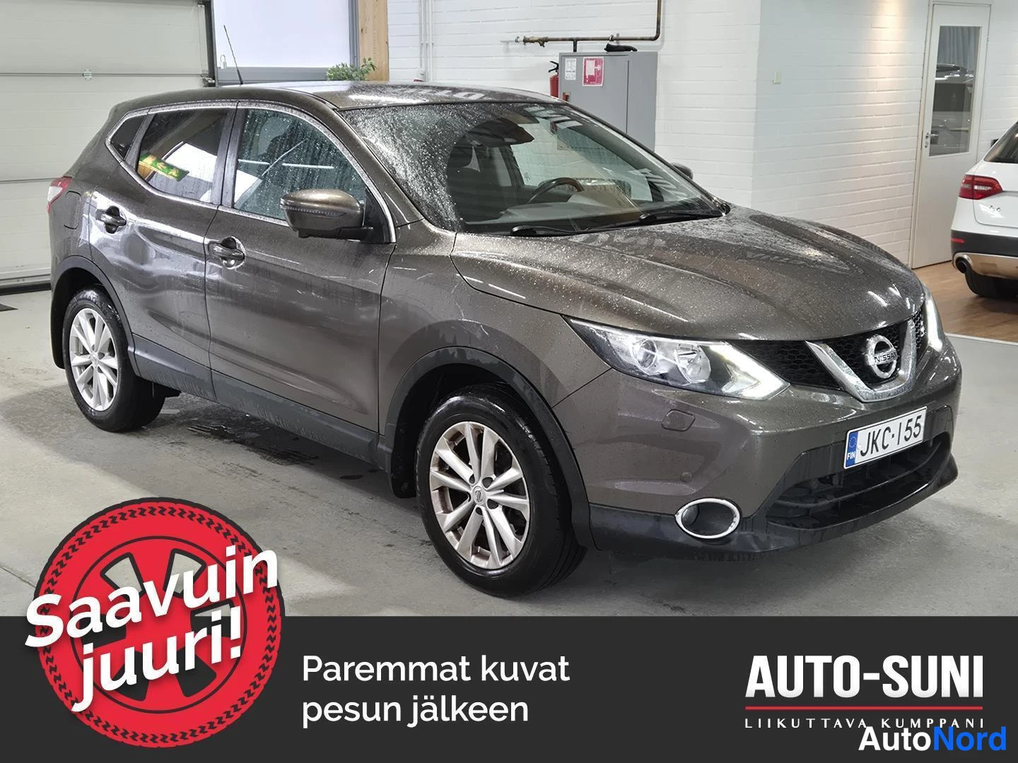 Etuviisto, nokka oikealle: Ruskea Nissan Qashqai colmelta neljäsosakulmasta etusivustaan, rekisteritunnus, sisätiloissa autonhallissa.