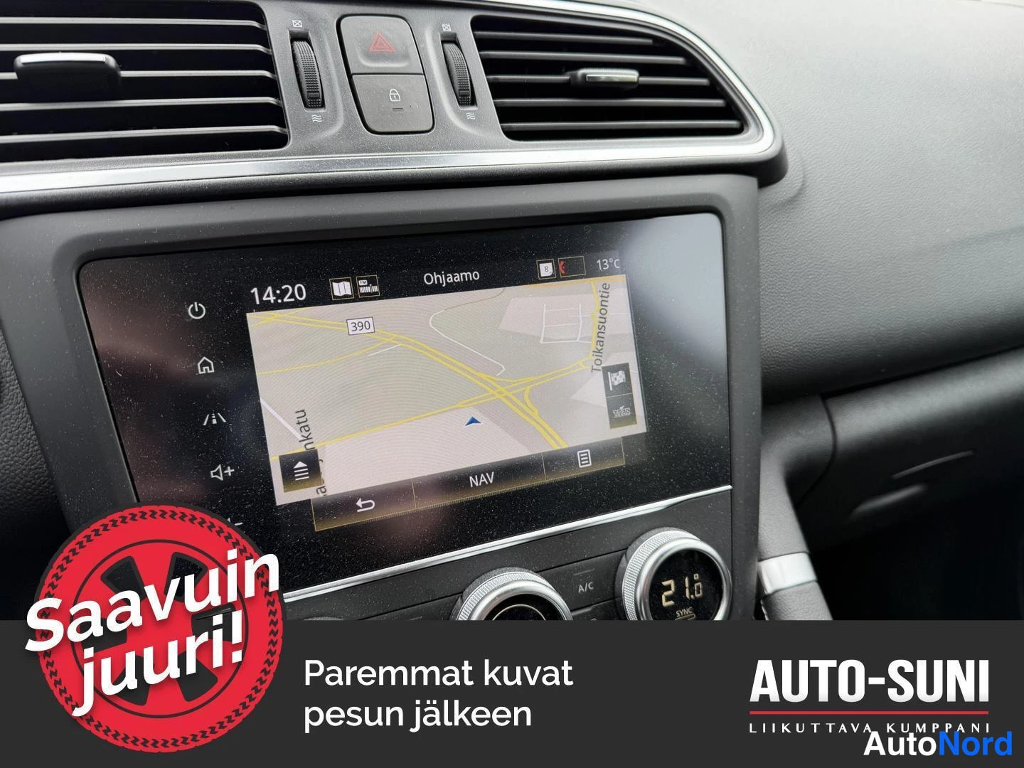 Muu: Kojelaudan keskikonsolin infotainment-näyttö näyttää navigointikarttaa; A/C-painike ja SYN-kaiutinsäädin näkyvät.