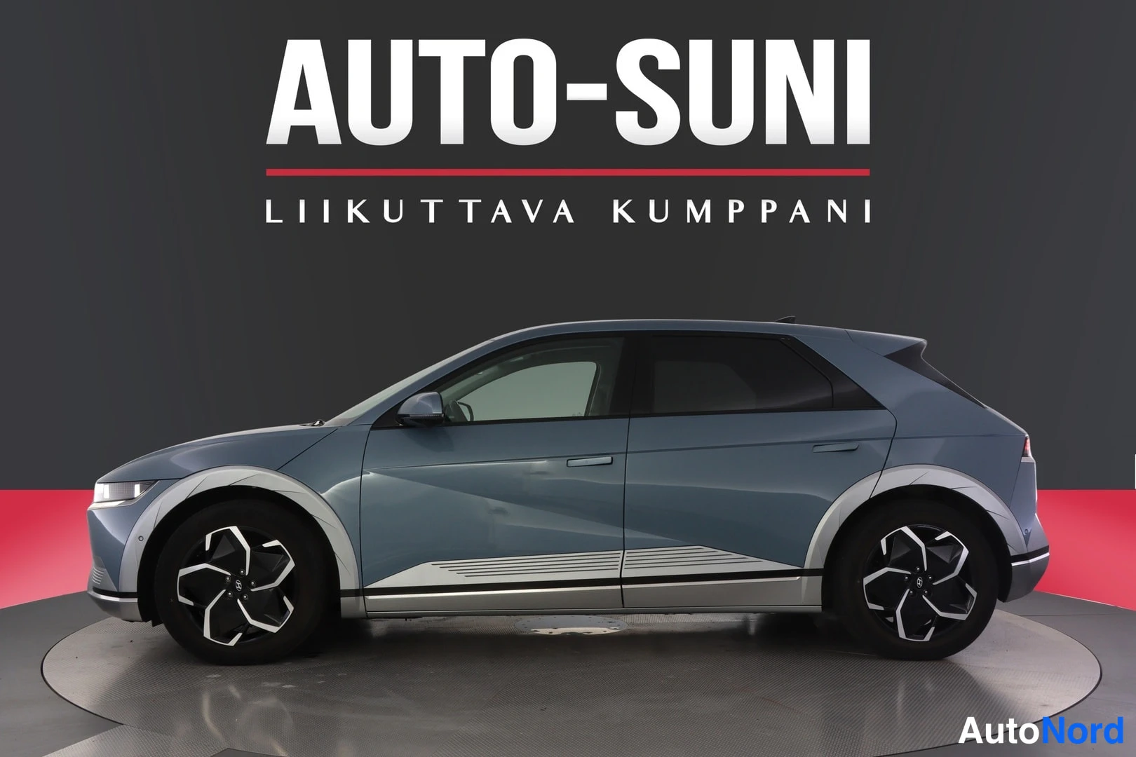 Etuviisto, nokka vasemmalle: Sinertävänharmaa Hatchback auton sivukuva studiotaustaa vasten, kylki ja etuosa näkyvissä.