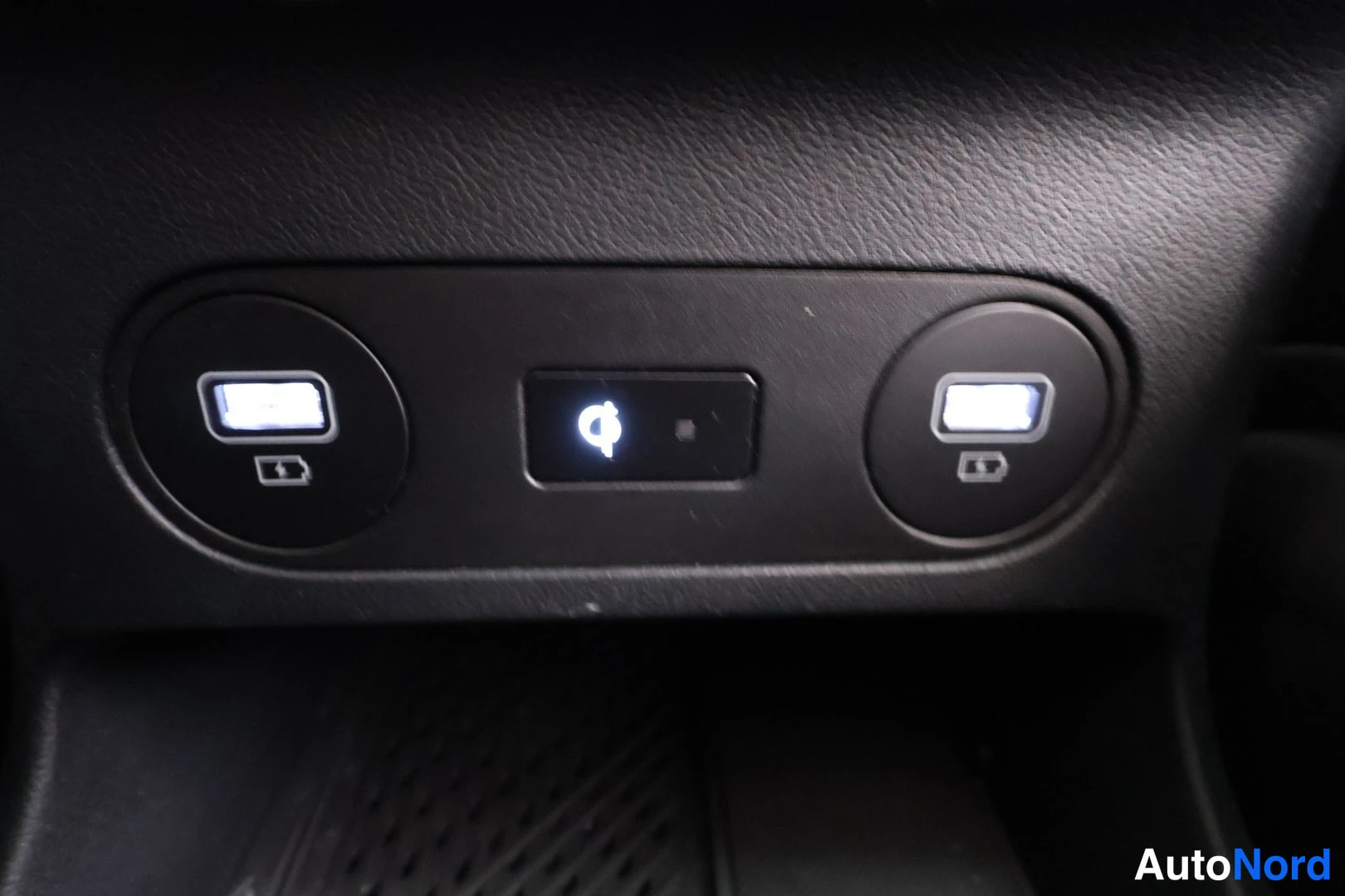 Yksityiskohta: Kaksi USB-latausporttia ja langaton latausala kojelaudan alapaneelissa