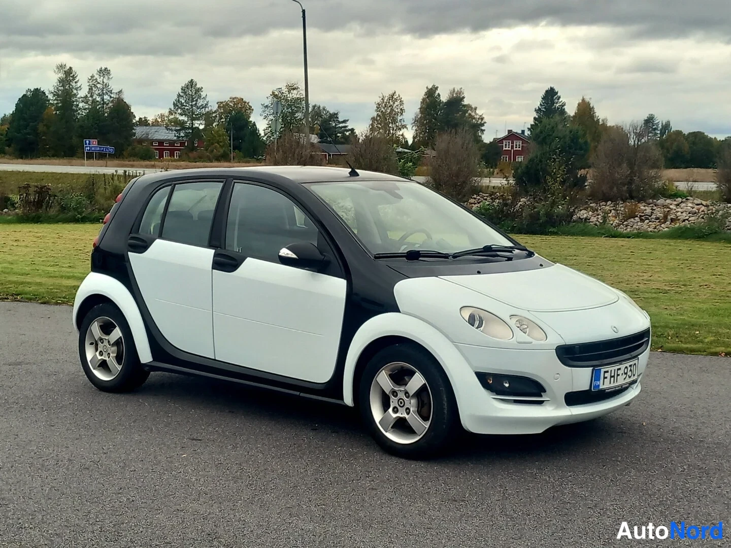 Etuviisto, nokka oikealle: Valkoinen ja musta Smart Forfour -henkilöauto etuviistosta oikealta kuvattuna, rekisterikilpi.