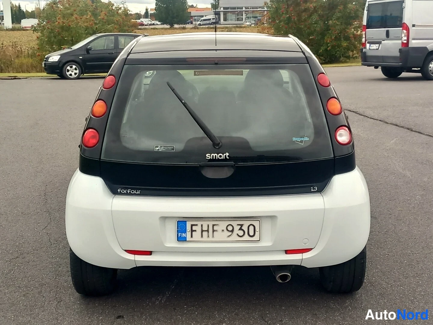 Takaa: Smart Forfour -henkilöauton takanäkymä: takalasinpyyhkijä, 'smart'- ja 'forfour'-tekstit, 13-merkintä, rekisterikilpi.