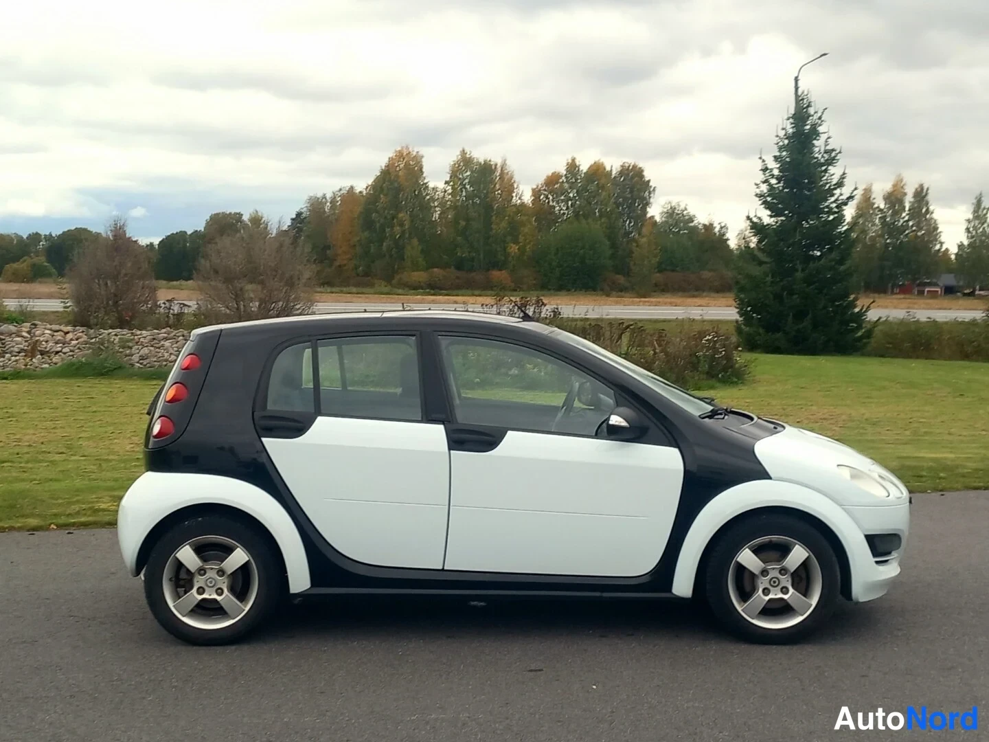 Etuviisto, nokka oikealle: Smart Forfour -auton kolmasosanäkymä etuosasta oikealle: valkoinen konepelti, musta katto, viisi oviaukkoa ja hopeiset vanteet.