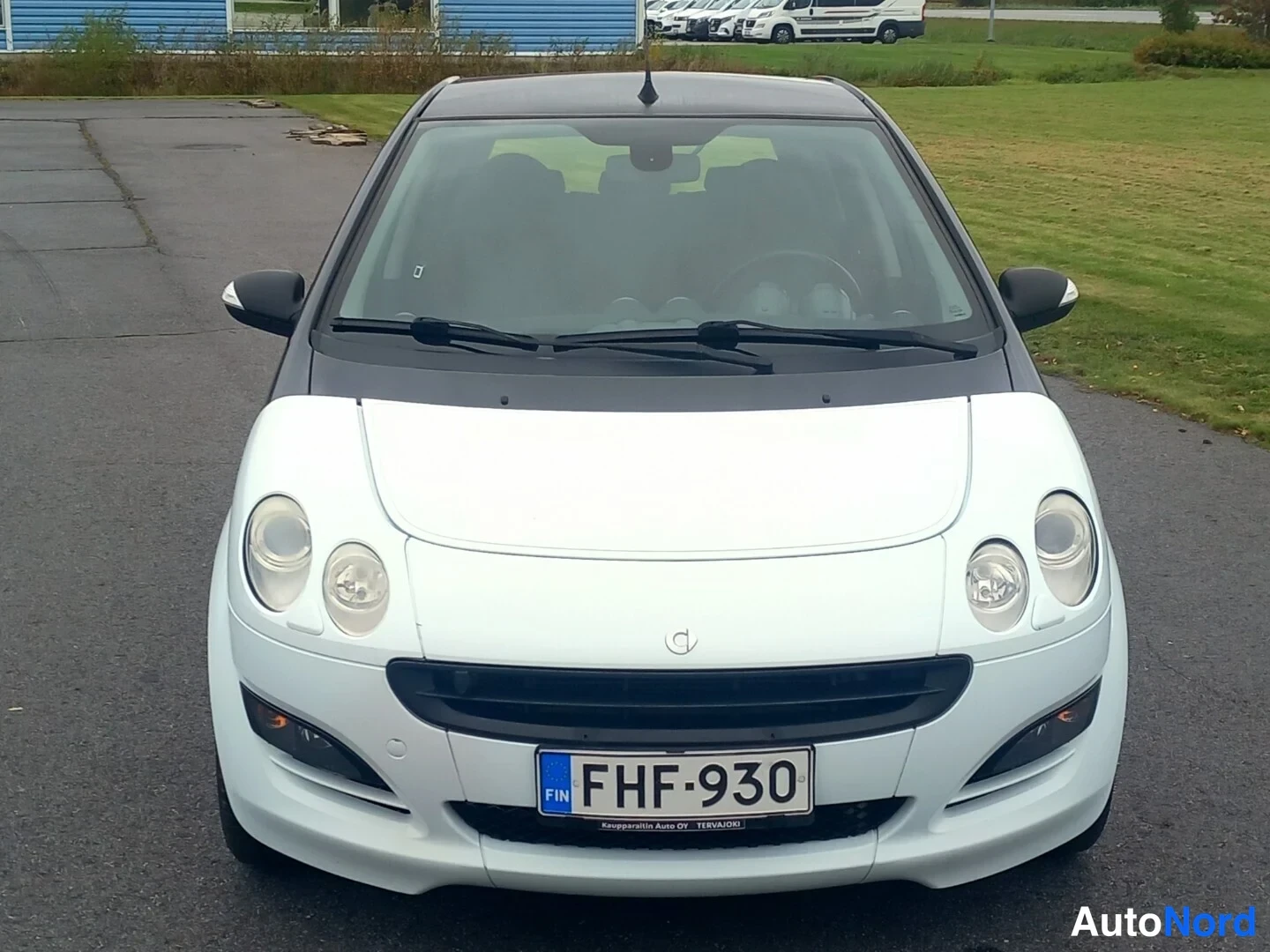 Edestä: Smart Forfour -henkilöauton etunäkymä: valkoinen konepelti ja etupaneelit, tumma katto, rekisterikilpi.