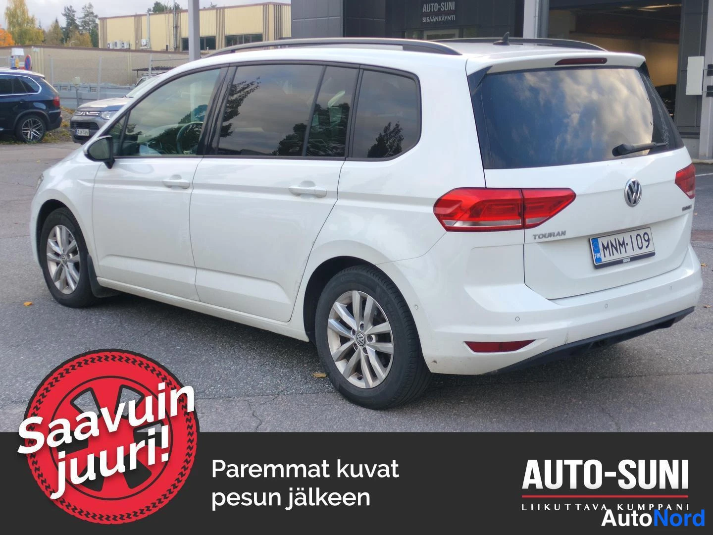 Takaviisto: Valkoinen Volkswagen Touran taka­kulmasta oikealta, takana Touran-teksti ja rekisteritunnus.