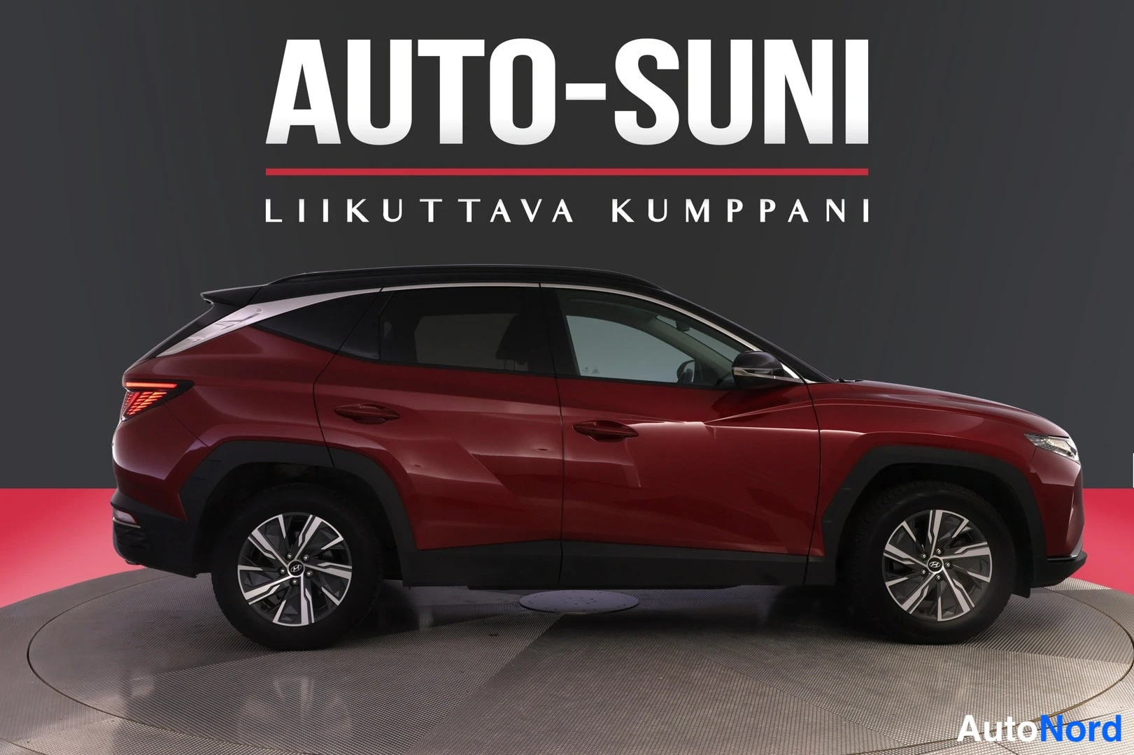 Sivulta: Punainen SUV sivusta nähtynä studio-ympäristössä, takaosaa ja etuosan reunoja näkyy hieman.
