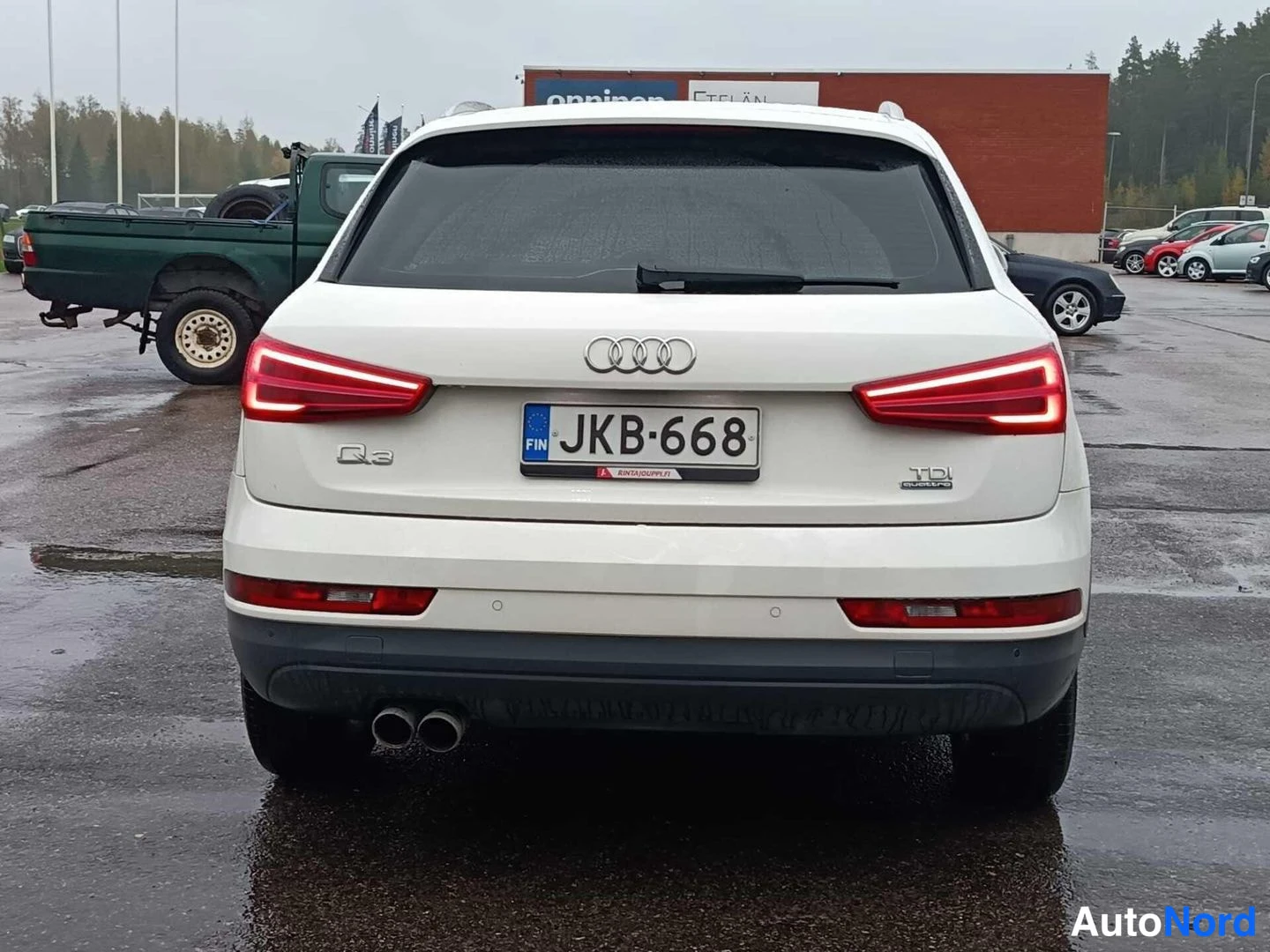 Takaa: Valkoinen Audi Q3 suoraan takaa kuvattuna, takavalot palavat ja rekisterikilpi on näkyvissä.