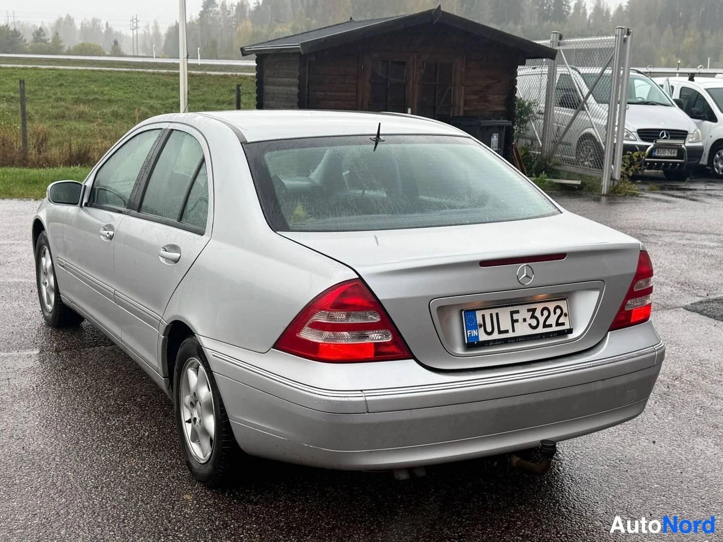 Takaviisto: Hopeanharmaa Mercedes-Benz C-sarjan sedan takaa vasemmalta kolmantenaäkuvana, rekisteritunnus.