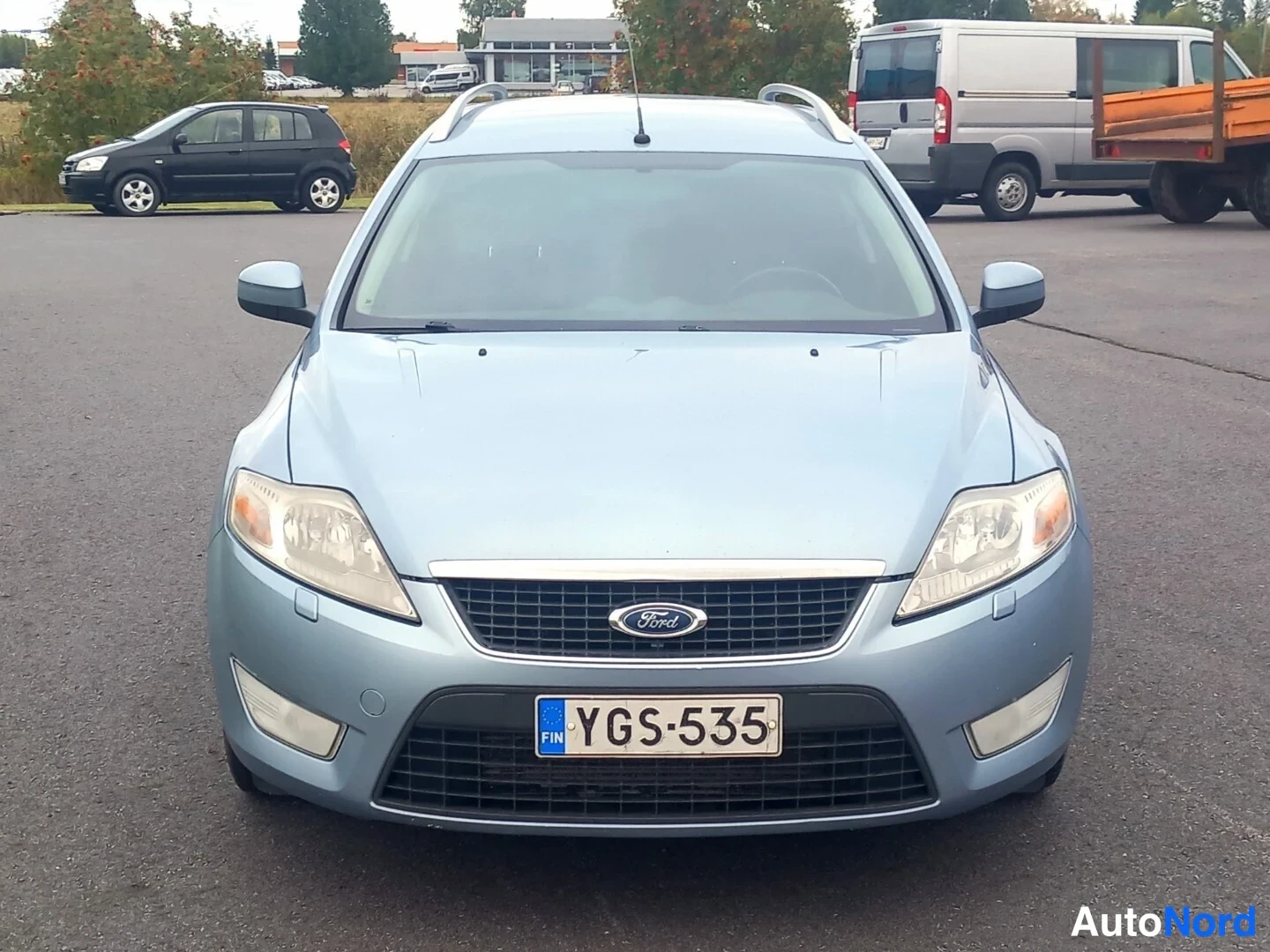 Edestä: Vaaleansininen Ford Mondeo -farmari kuvattuna suoraan edestä; Ford-merkki etusäleikössä, rekisterikilpi ja kattokaiteet näkyvissä.