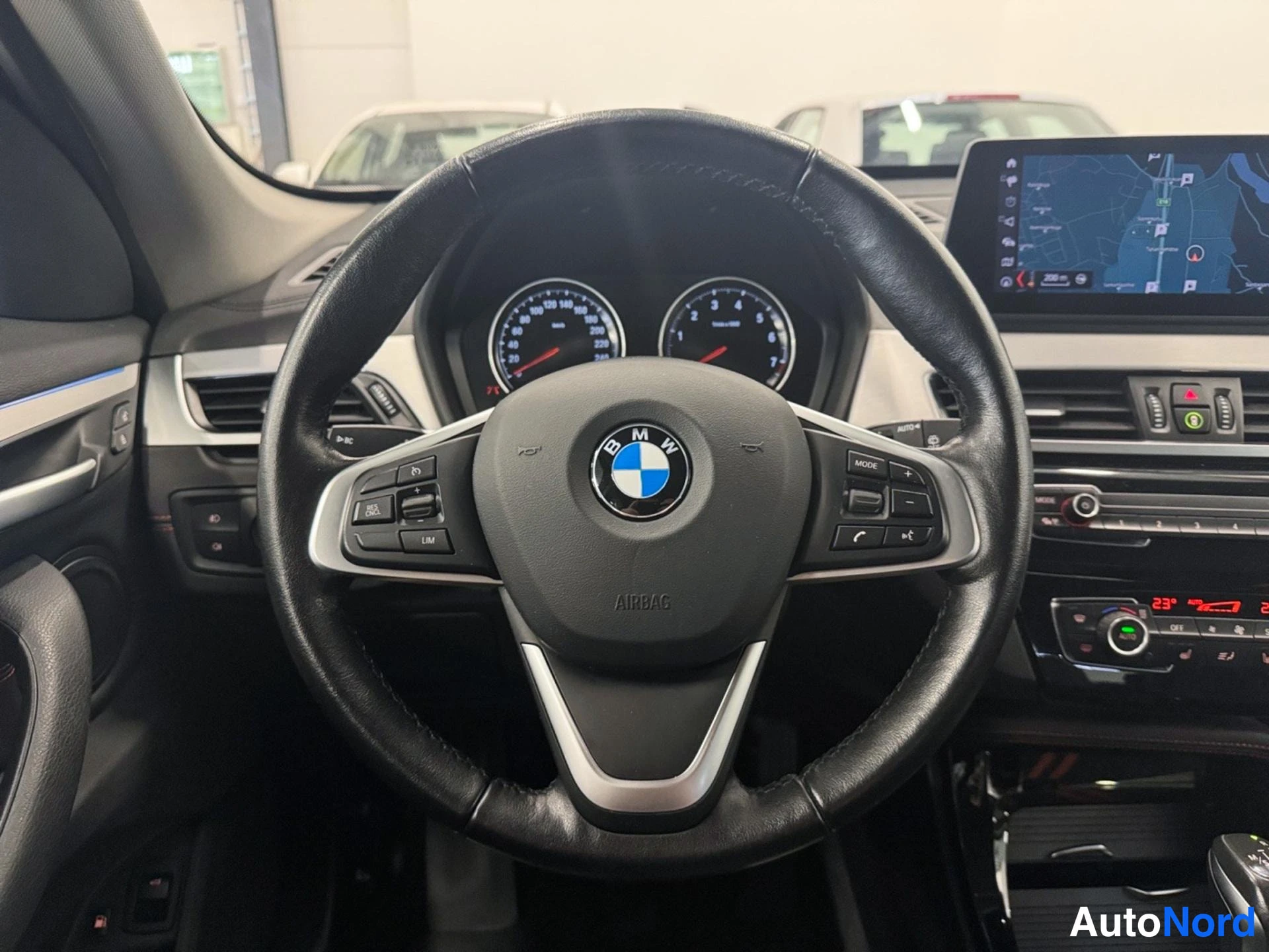 Muu: Sisäkuva: BMW-monitoimiohjauspyörä, analogiset mittarit sekä keskinäytön karttanäkymä.