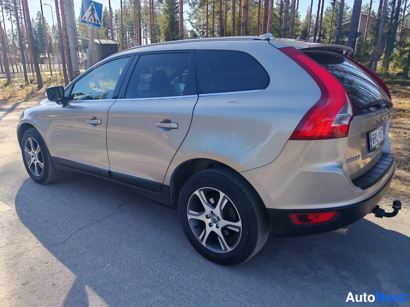 Takaviisto: Kulmakuva hopeanvärisen Volvo XC60:n takaosasta oikealta: takavalot, takaluukku, takapuskurissa kiinnitetty vetokoukun kaula ja rekisterikilpi näkyvät.