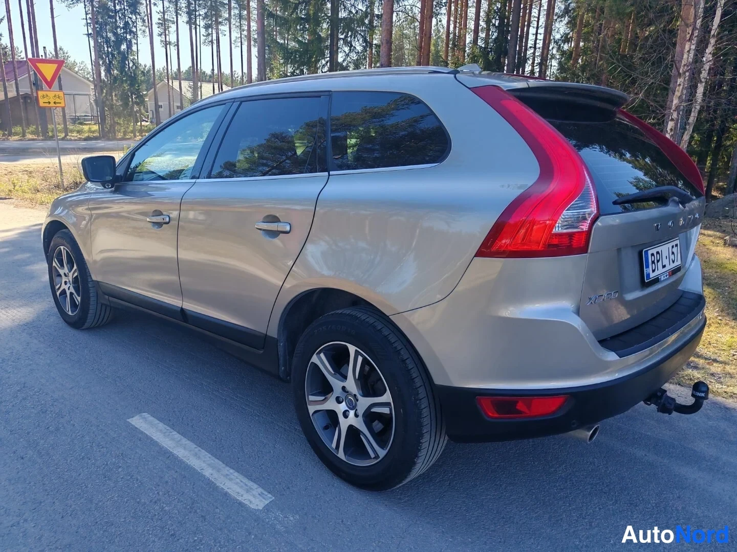 Takaviisto: Volvo XC60 vasemmalta takaviistosta: vasen kylki ja takapää näkyvissä, takavalot, XC60-merkki, rekisterikilpi BPL 157 ja vetokoukun pallo; korin väri on beige.