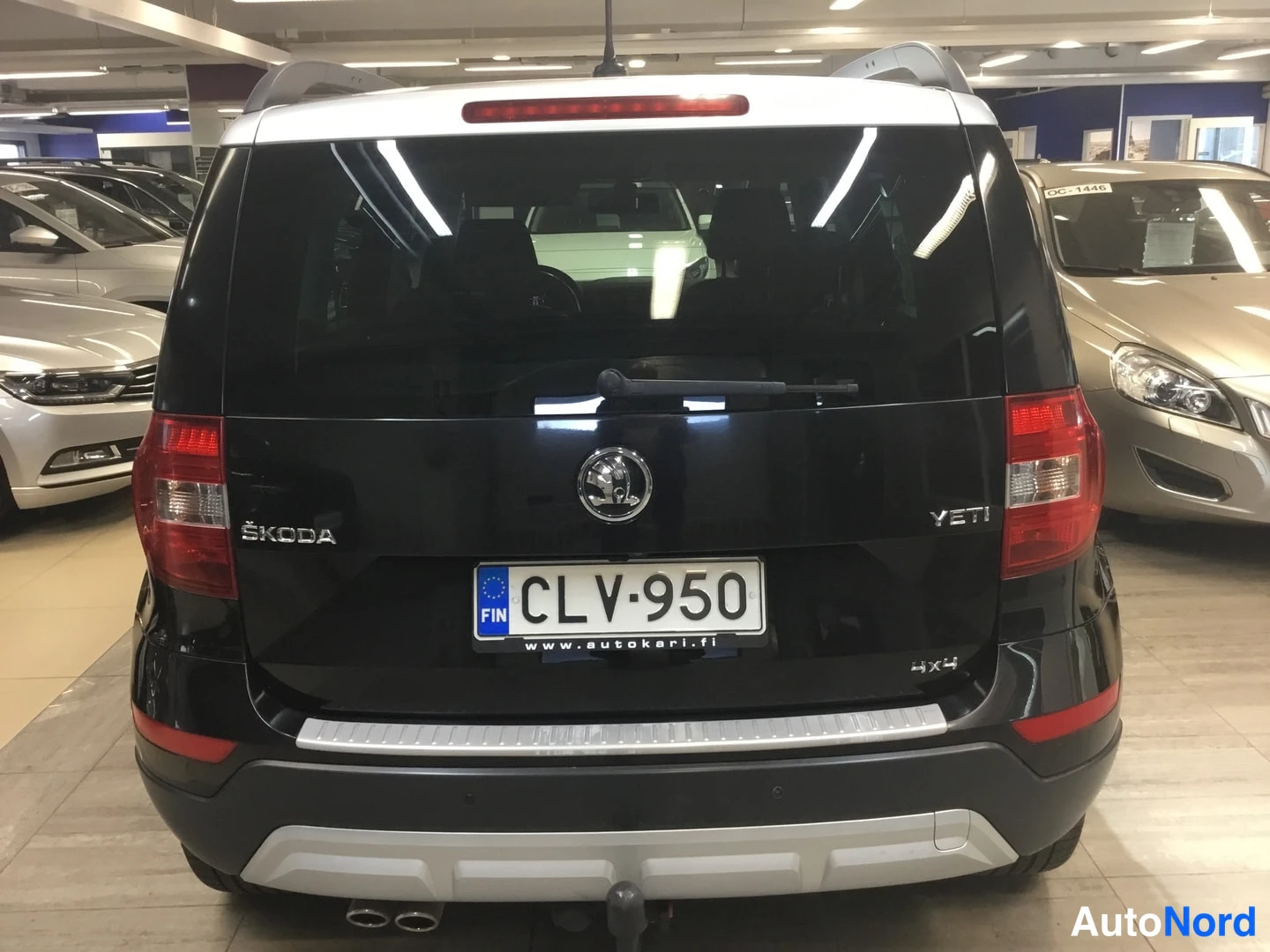 Takaa: Mustan Škodan takanäkymä, takavalojen välissä merkintä ŠKODA ja YETI, rekisterikilpi.