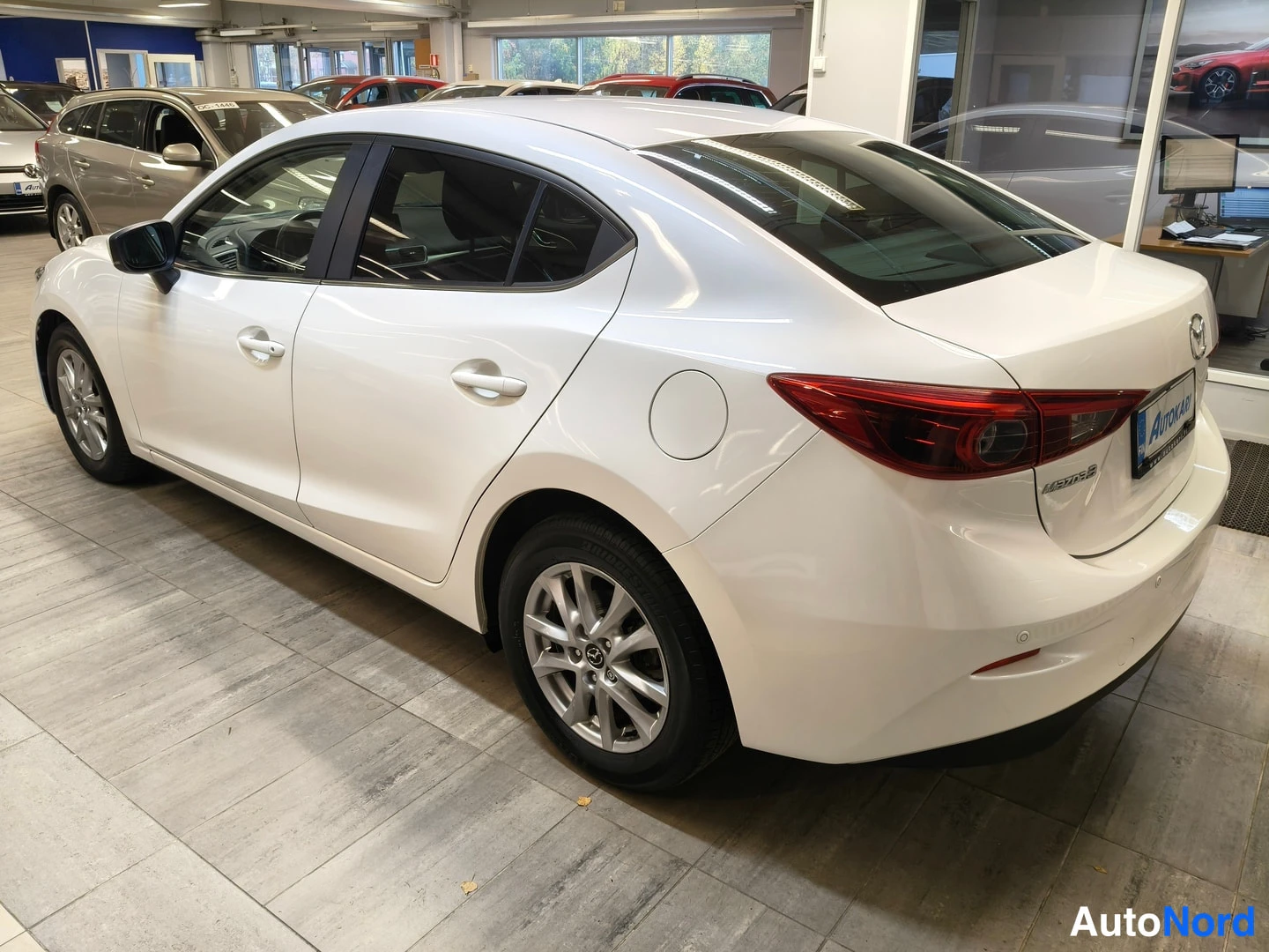 Takaviisto: Mazda3 sedan takaviisto, valkoinen.