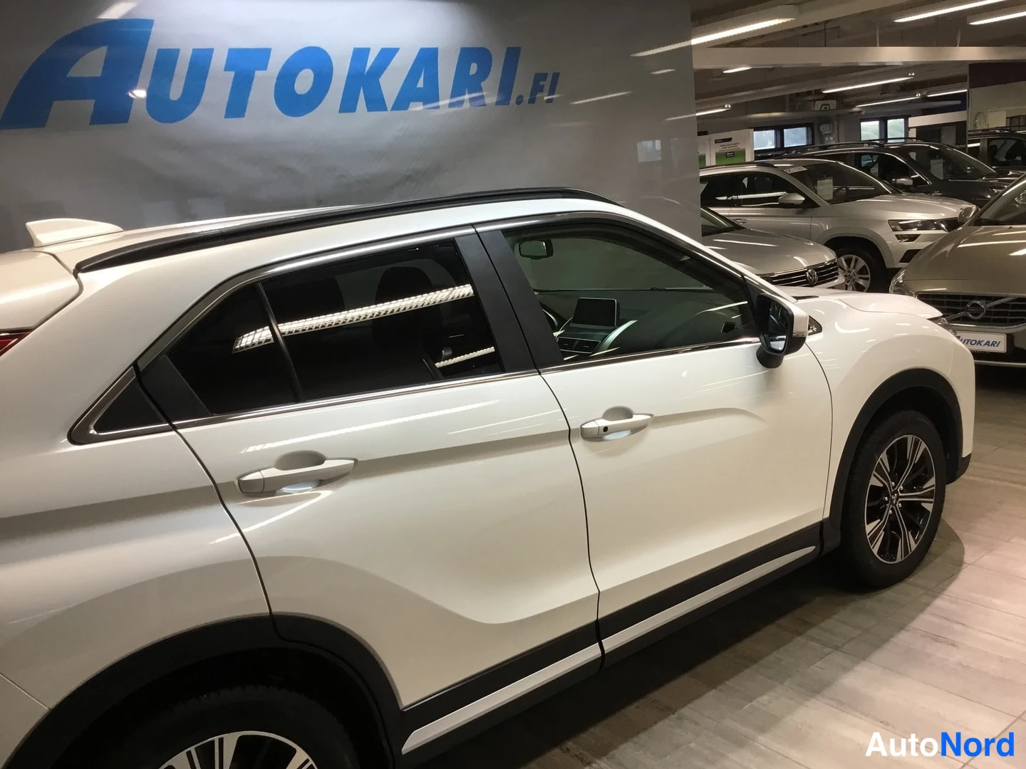 Sivulta: Valkoisen Mitsubishi Eclipse Crossin kylkinäkymä autonosalta.