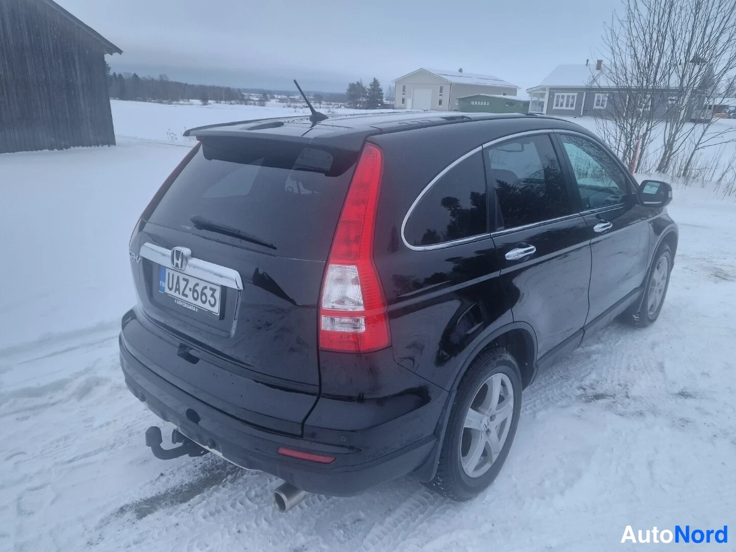 Takaviisto: Musta Honda CR-V takaa vasemmalta kolmanneltsektiolta lumessa; rekisterikilpi ja vetokoukku näkyvät.