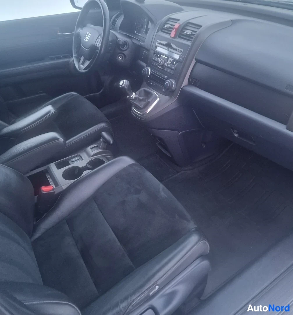 Muu: Honda CR-V:n sisätilat ylhäältä: kaksi etuistuinta, käsivaihteet ja keskikonsolin kupit.