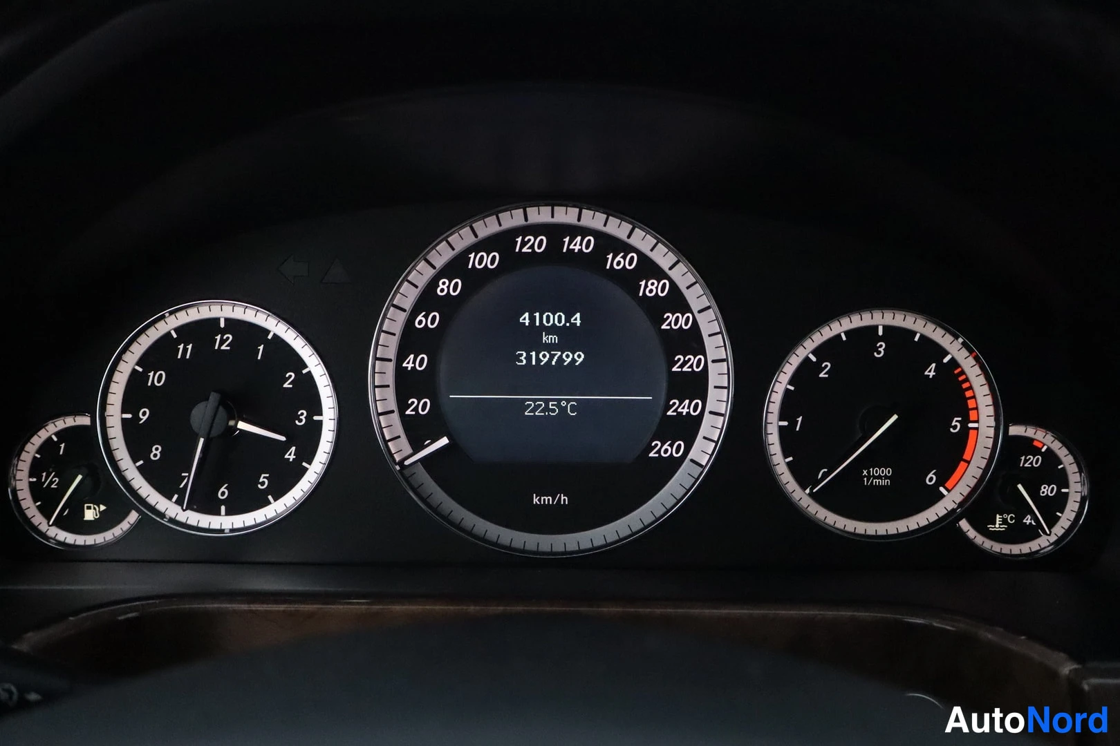 Yksityiskohta: Kojelaudan mittaristo nopeusmittarilla ja matkamittarilla, lukema 319799 km, ulkolämpötila 22,5 °C.